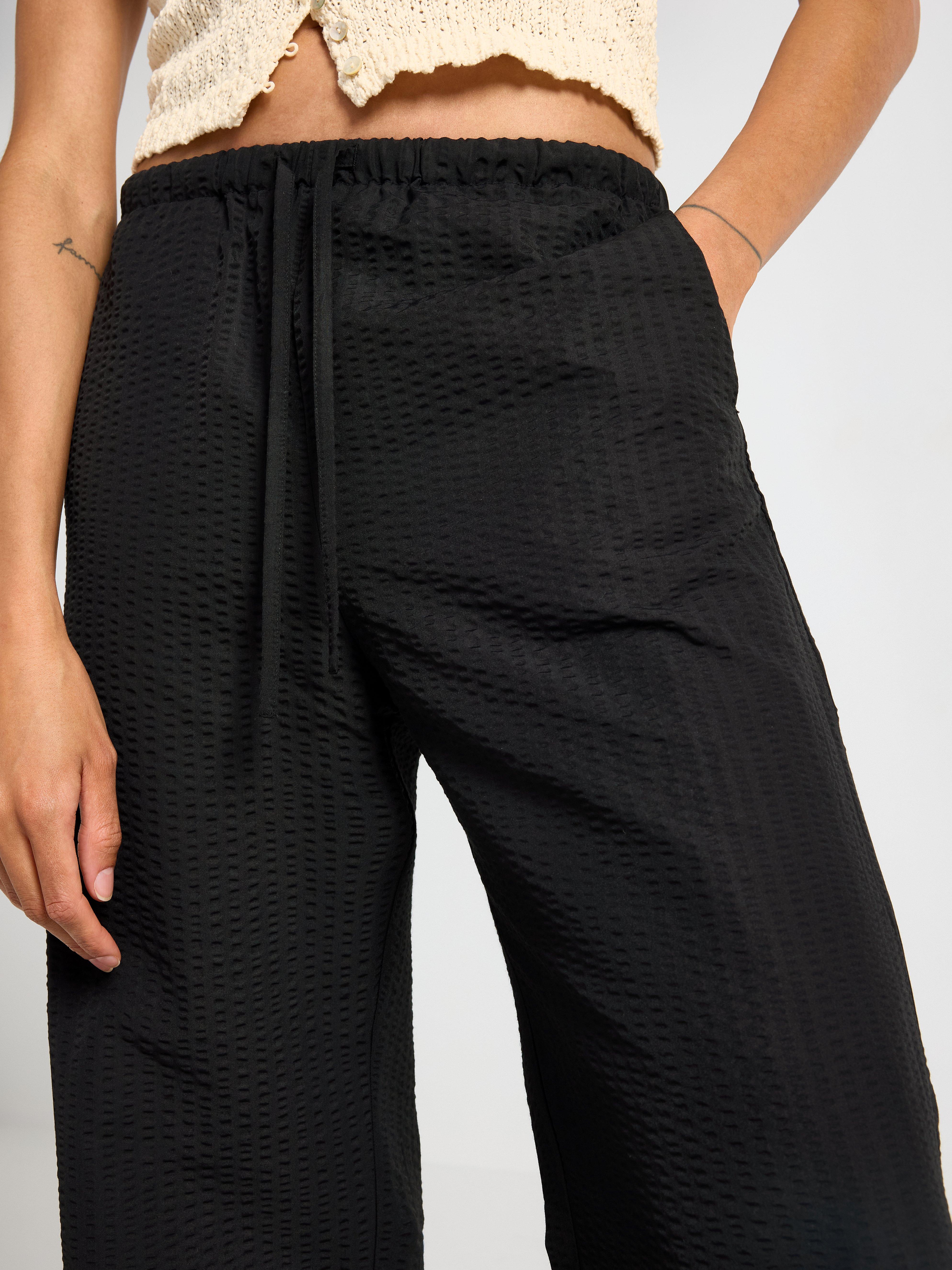 Pantalones rectos acampanados de color negro