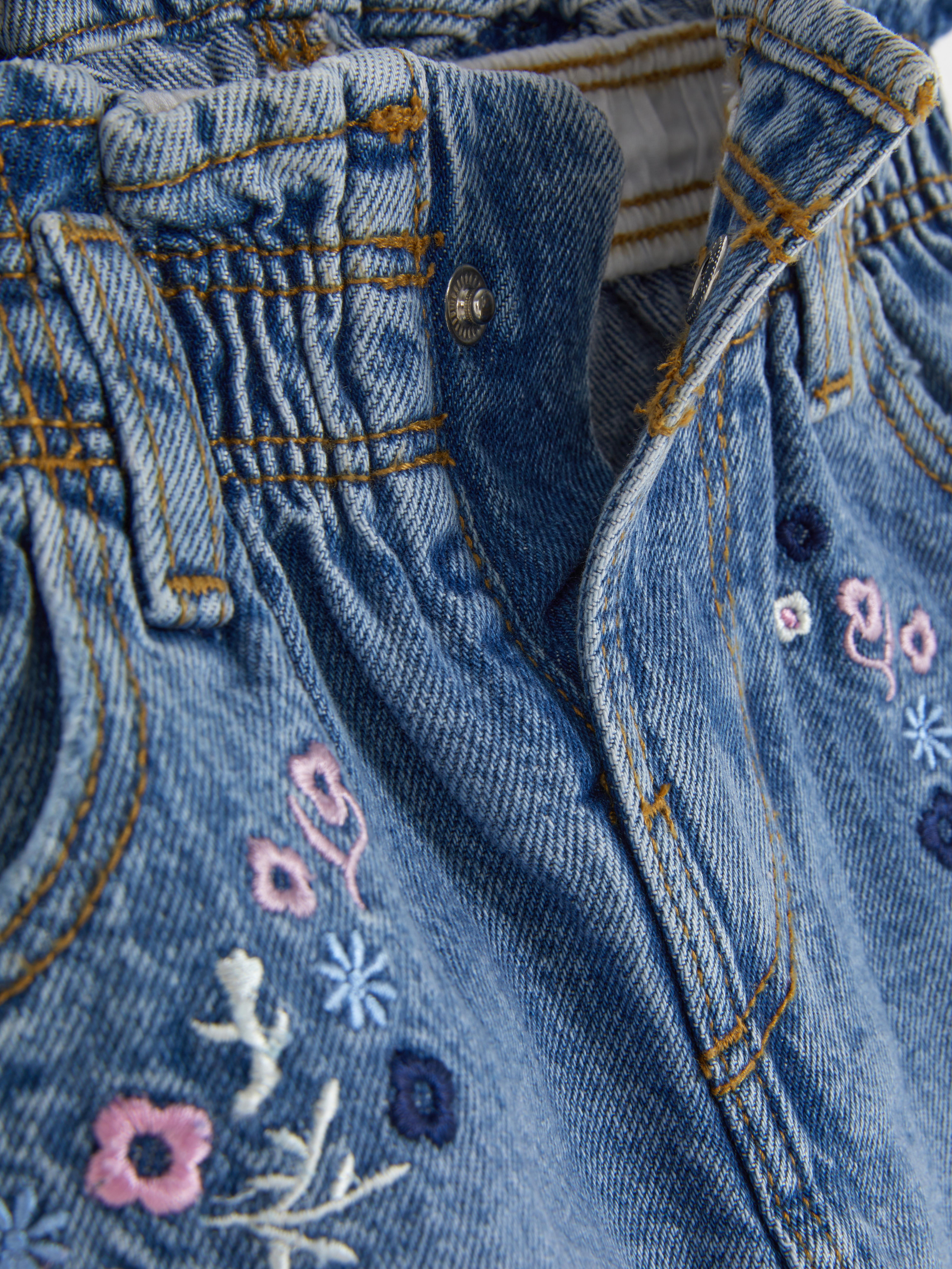 Jeansrock mit Blumenstickerei. Ein Jeansrock mit gestickten Blumen, elastischem Bund, Gürtelschlaufen und Taschen.