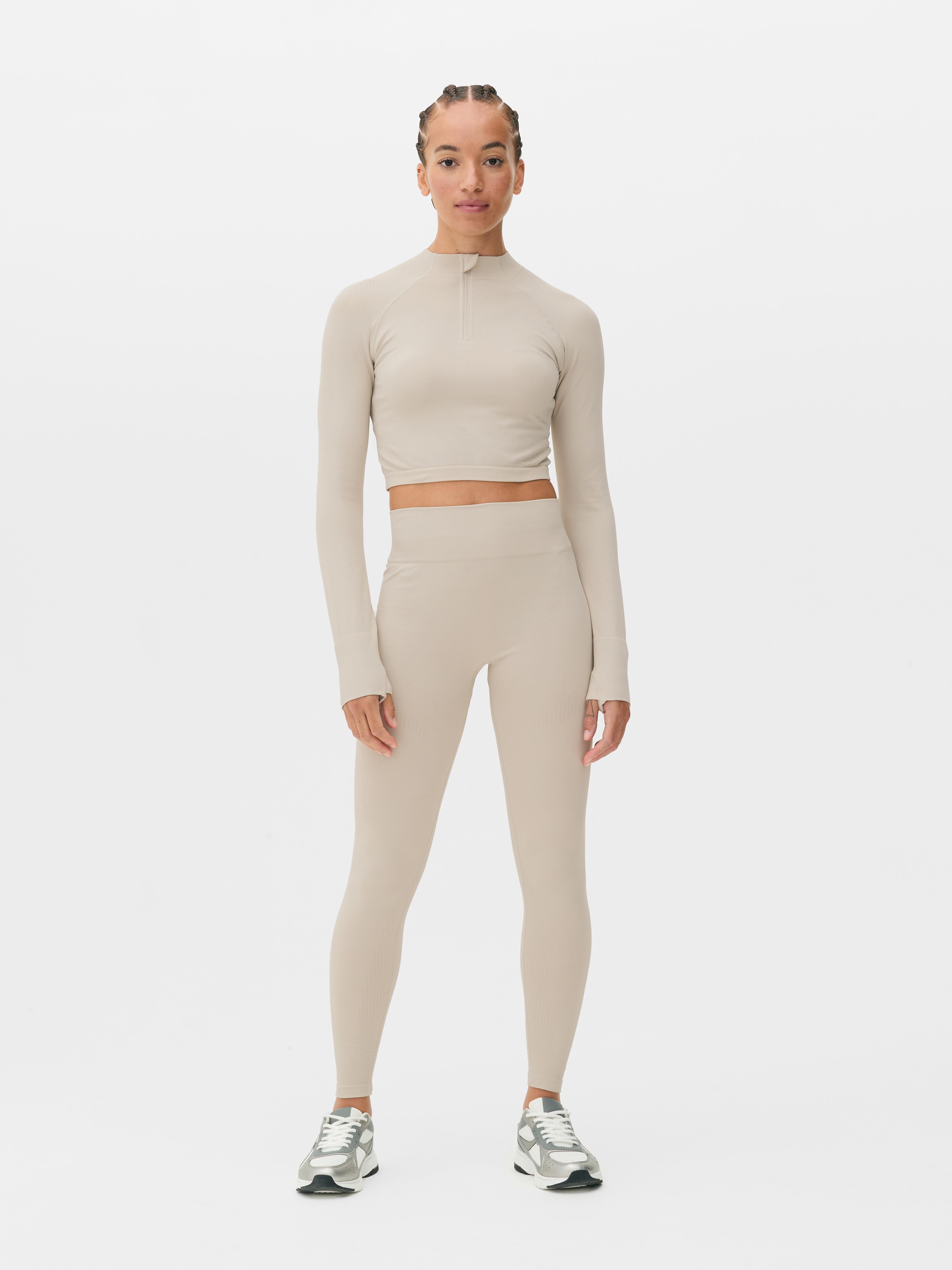 Top sport modelator cu mâneci lungi, fără cusături. Acest top sport scurt, cu fermoar pe jumătate și design fără cusături, este funcțional și elegant.