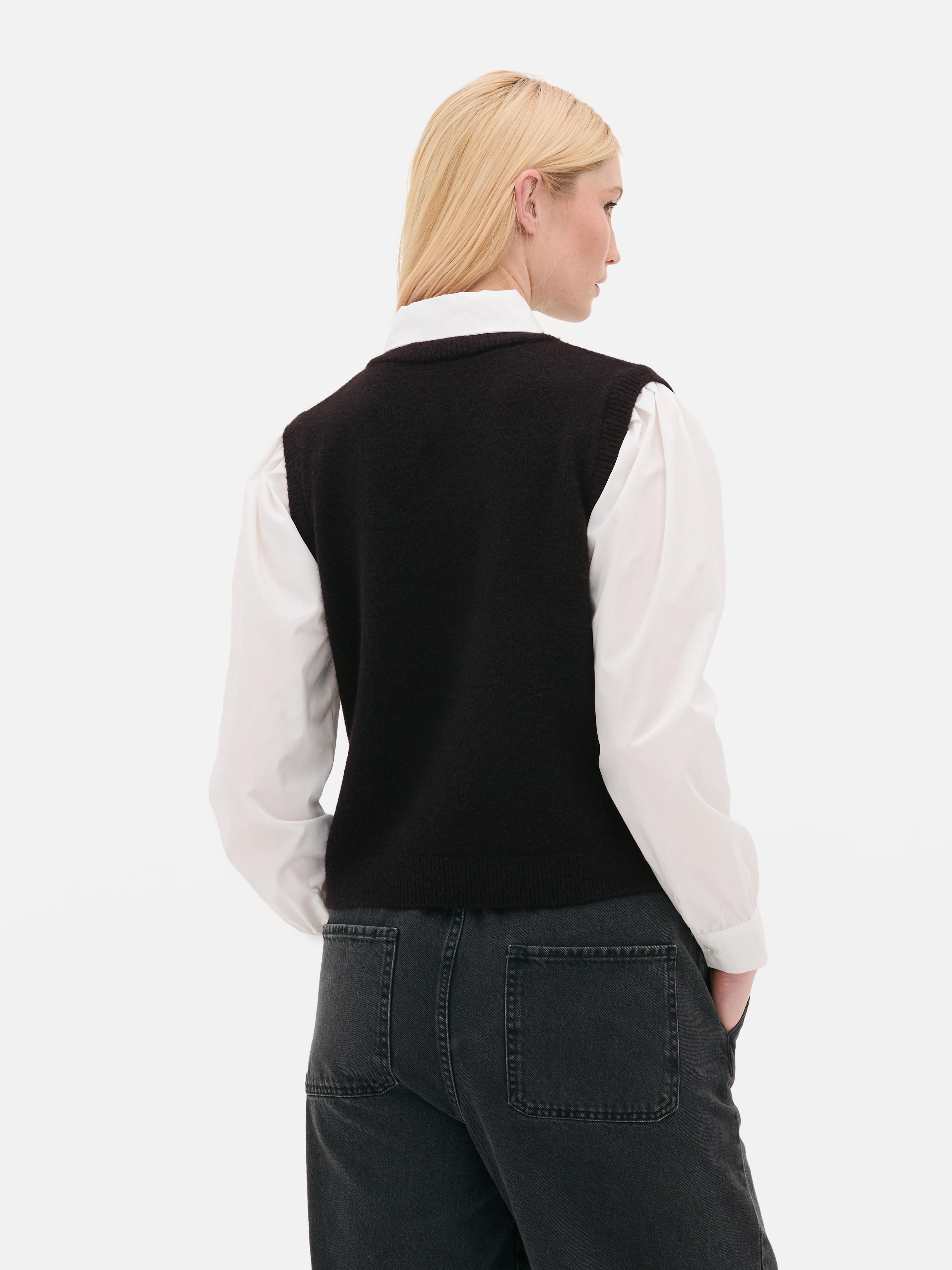 Camicia e gilet 2 in 1. Un gilet in maglia e una camicia con colletto e maniche lunghe con polsini.