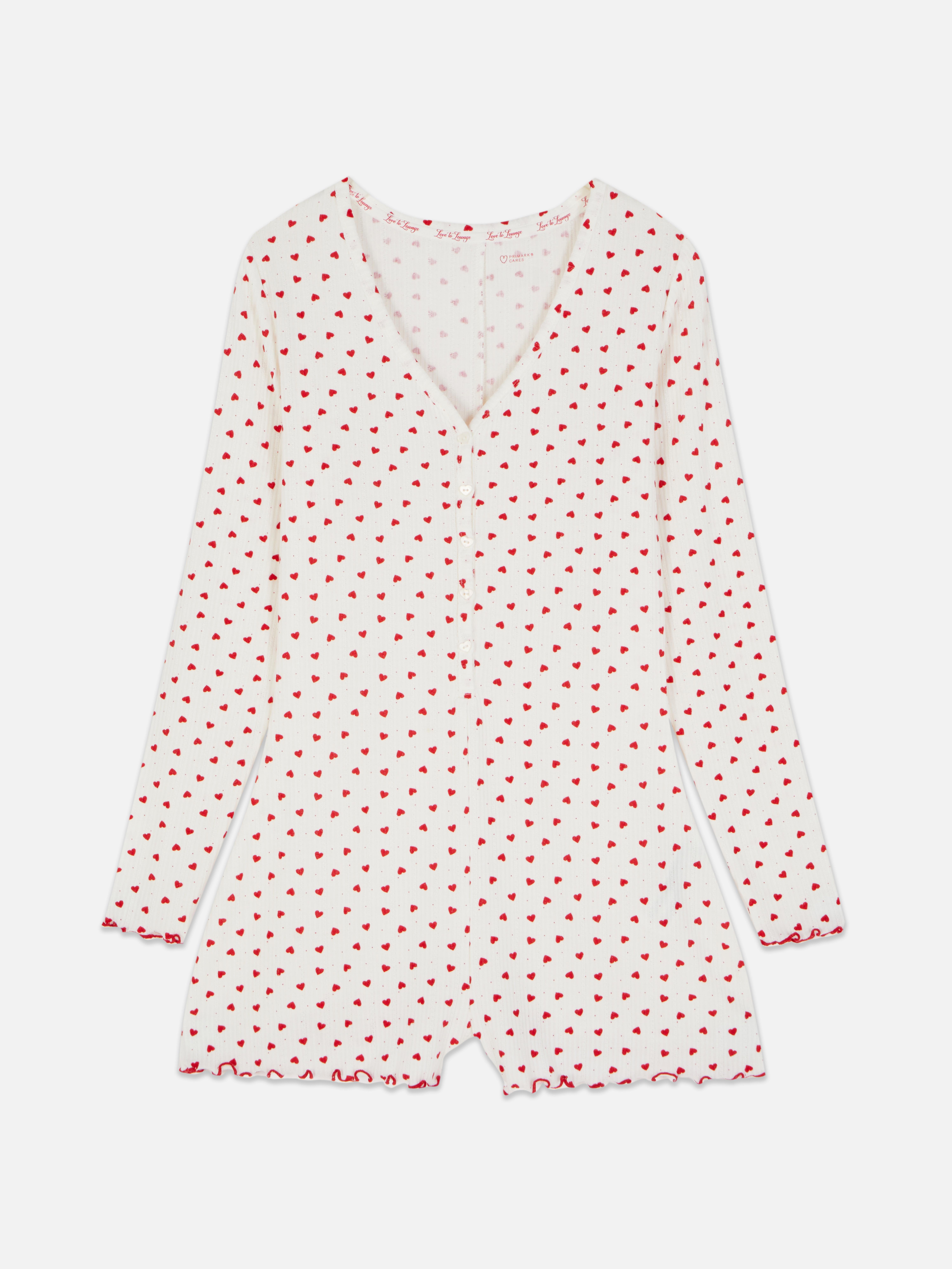 Salopetă de pijama cu model cu inimă. O salopetă de pijama confecționată din material moale cu nervuri, cu tiv festonat și model.