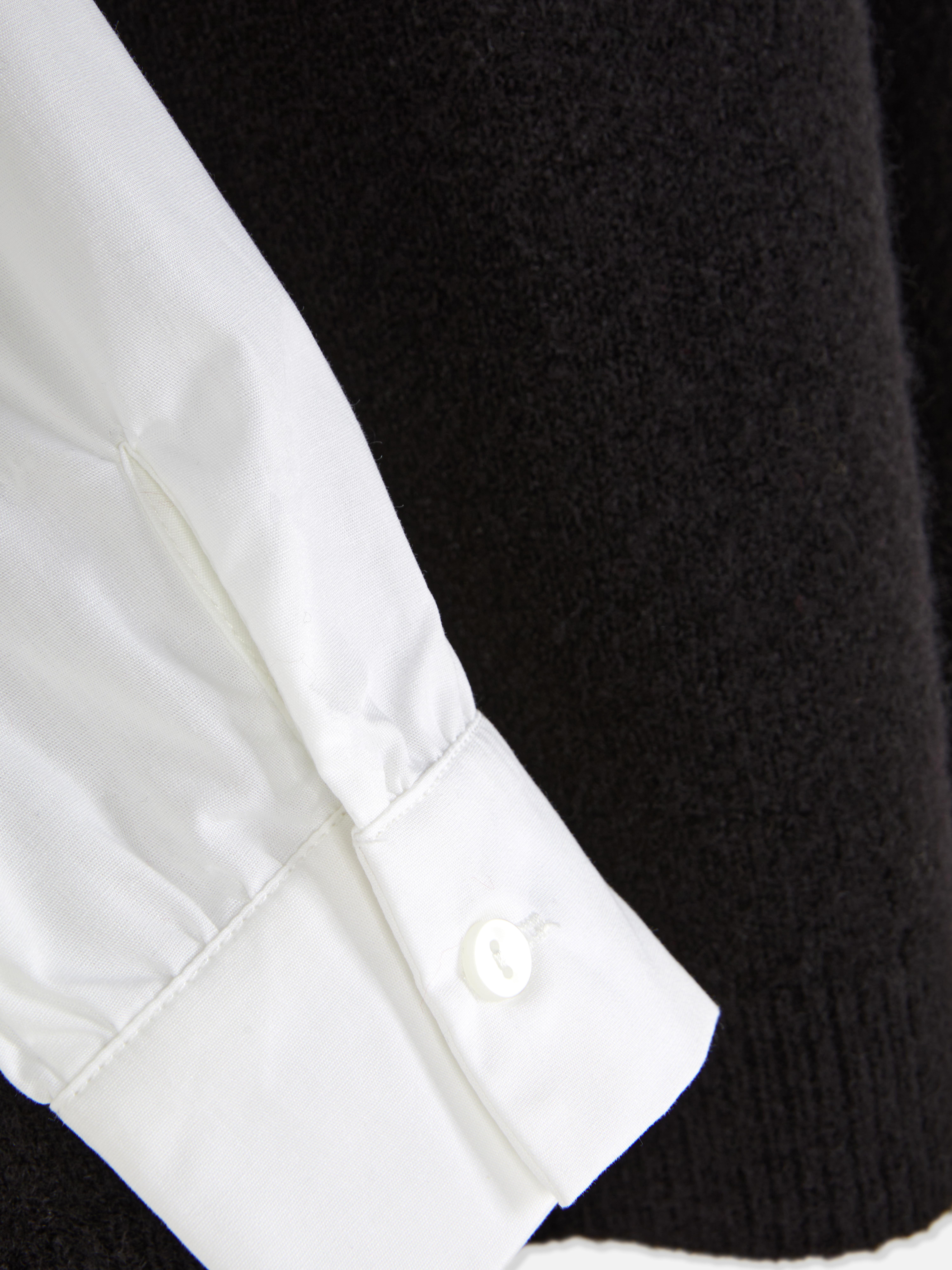 Camicia e gilet 2 in 1. Un gilet in maglia e una camicia con colletto e maniche lunghe con polsini.
