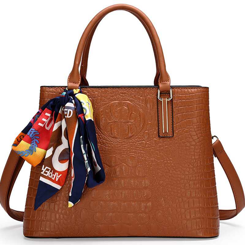 Sac à bandoulière élégant en cuir alligator pour femme, orné de rubans et d'une grande capacité.