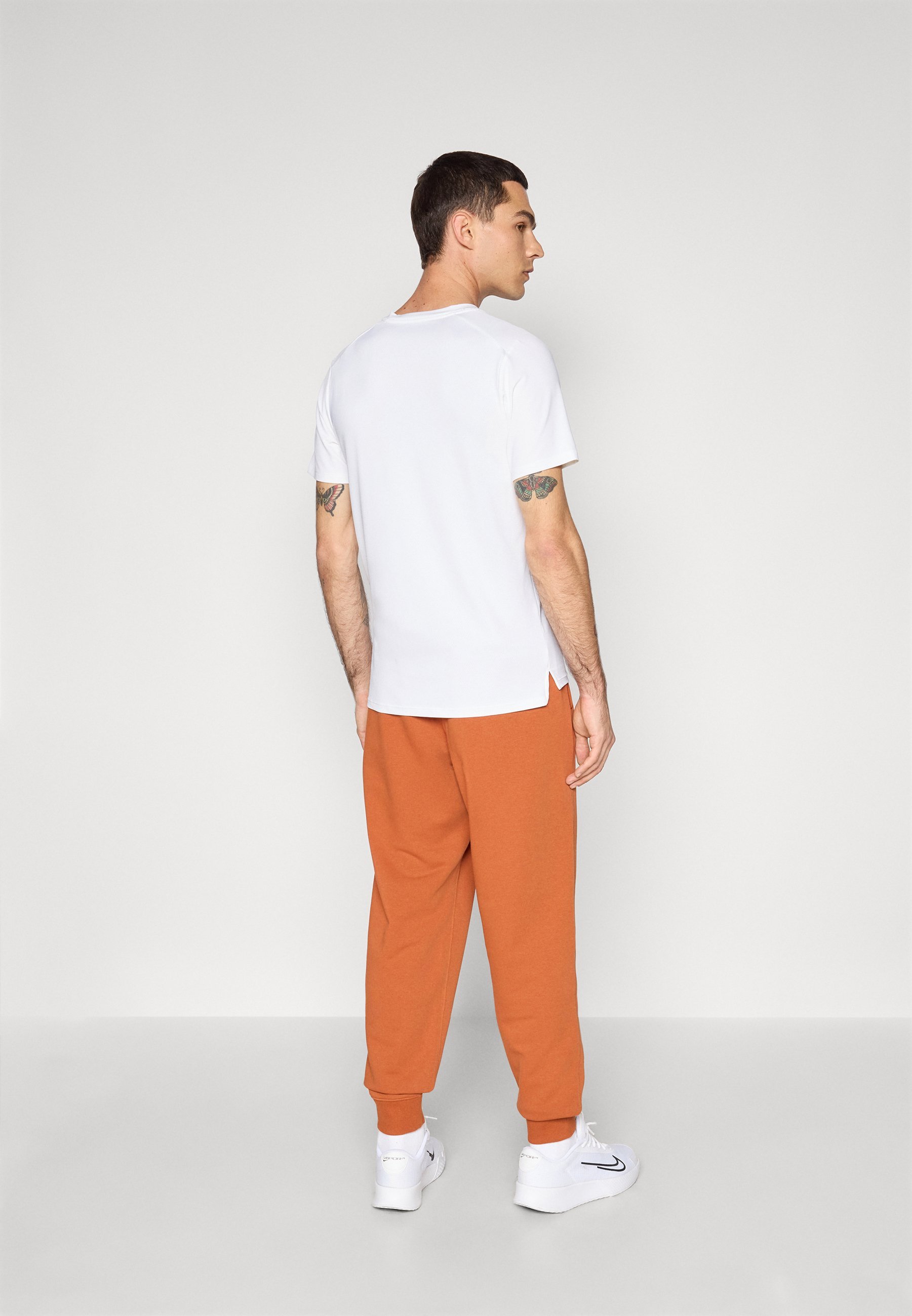 Pantalon de jogging Nike Performance NIKECOURT HERITAGE - Bas de survêtement - couleur rouille foncée
