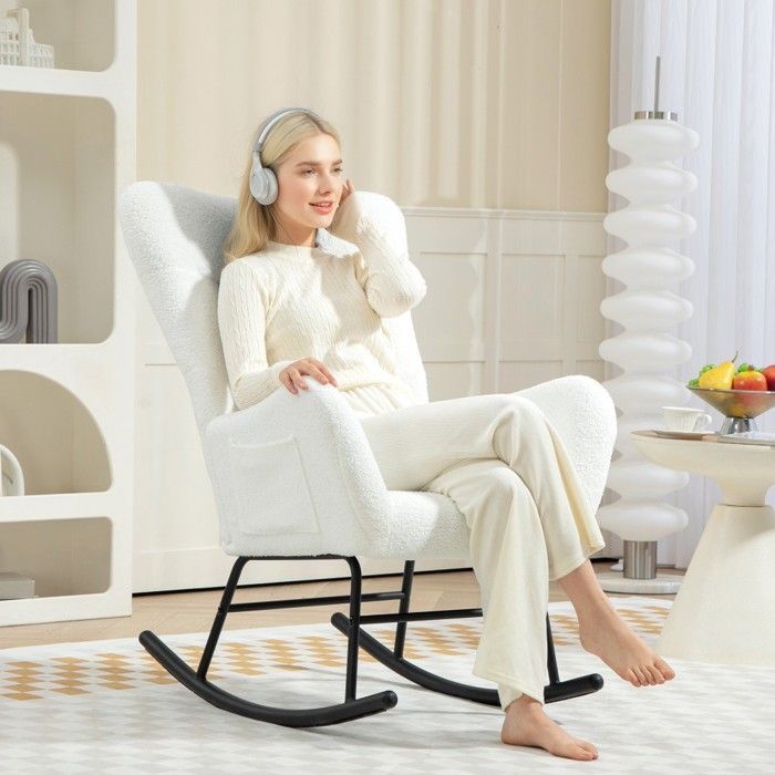 Mecedora blanca de felpa con reposabrazos y cojín lumbar, bolsillo lateral y deslizadores de madera. Ideal para sala de estar, dormitorio y lactancia.