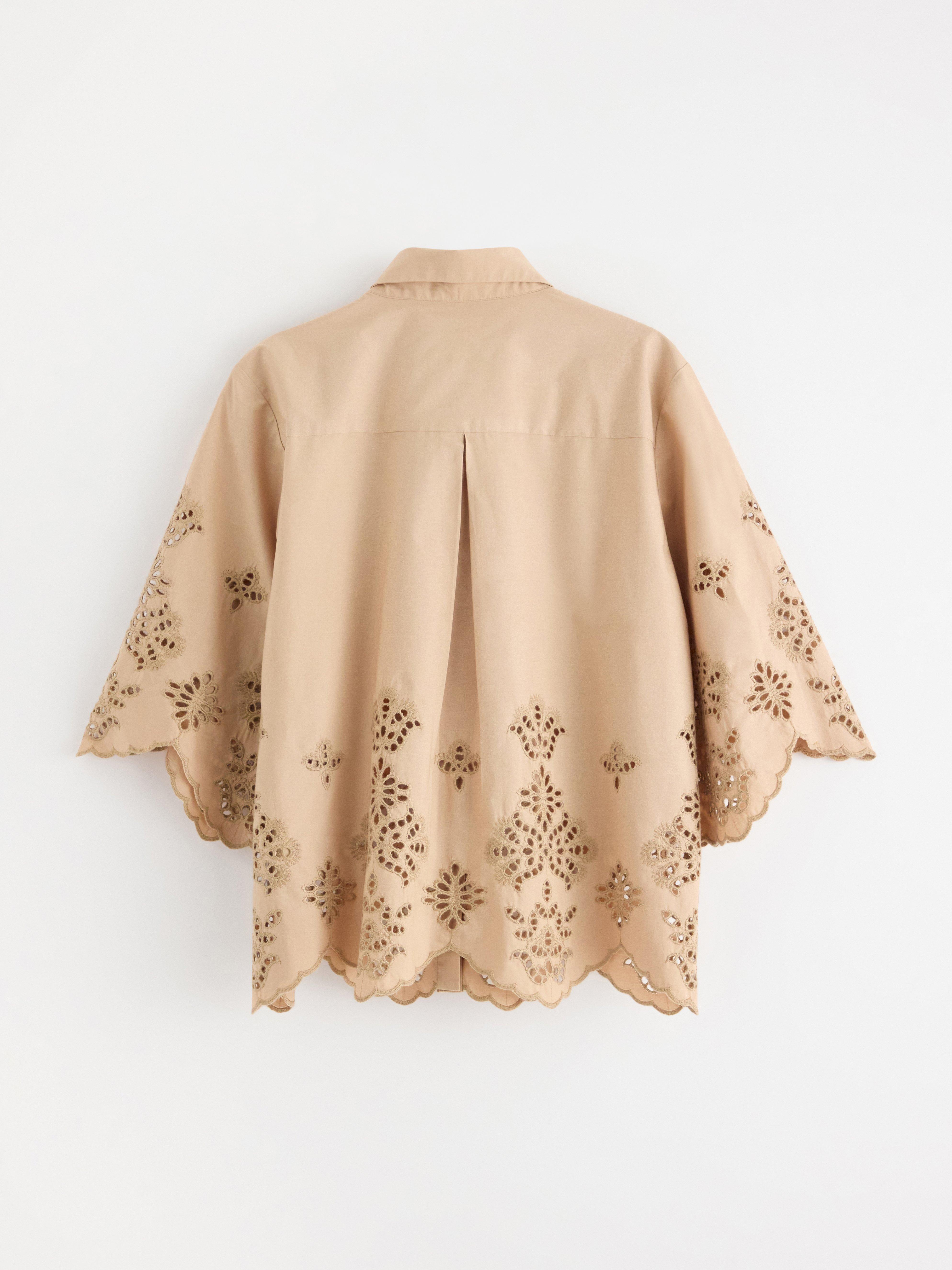 Camisa de manga curta bege com bordado.