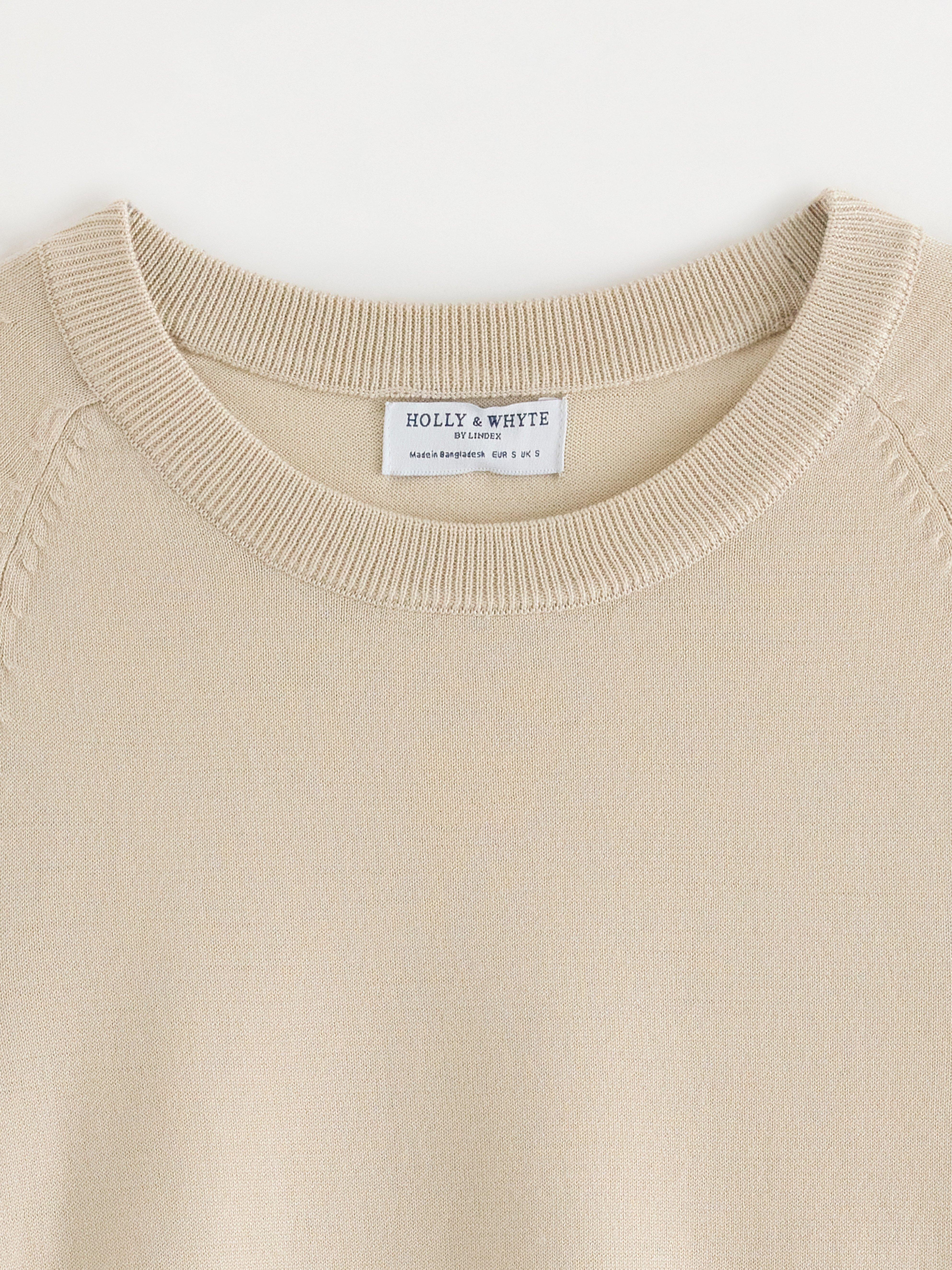 Jersey de punto fino color beige claro.