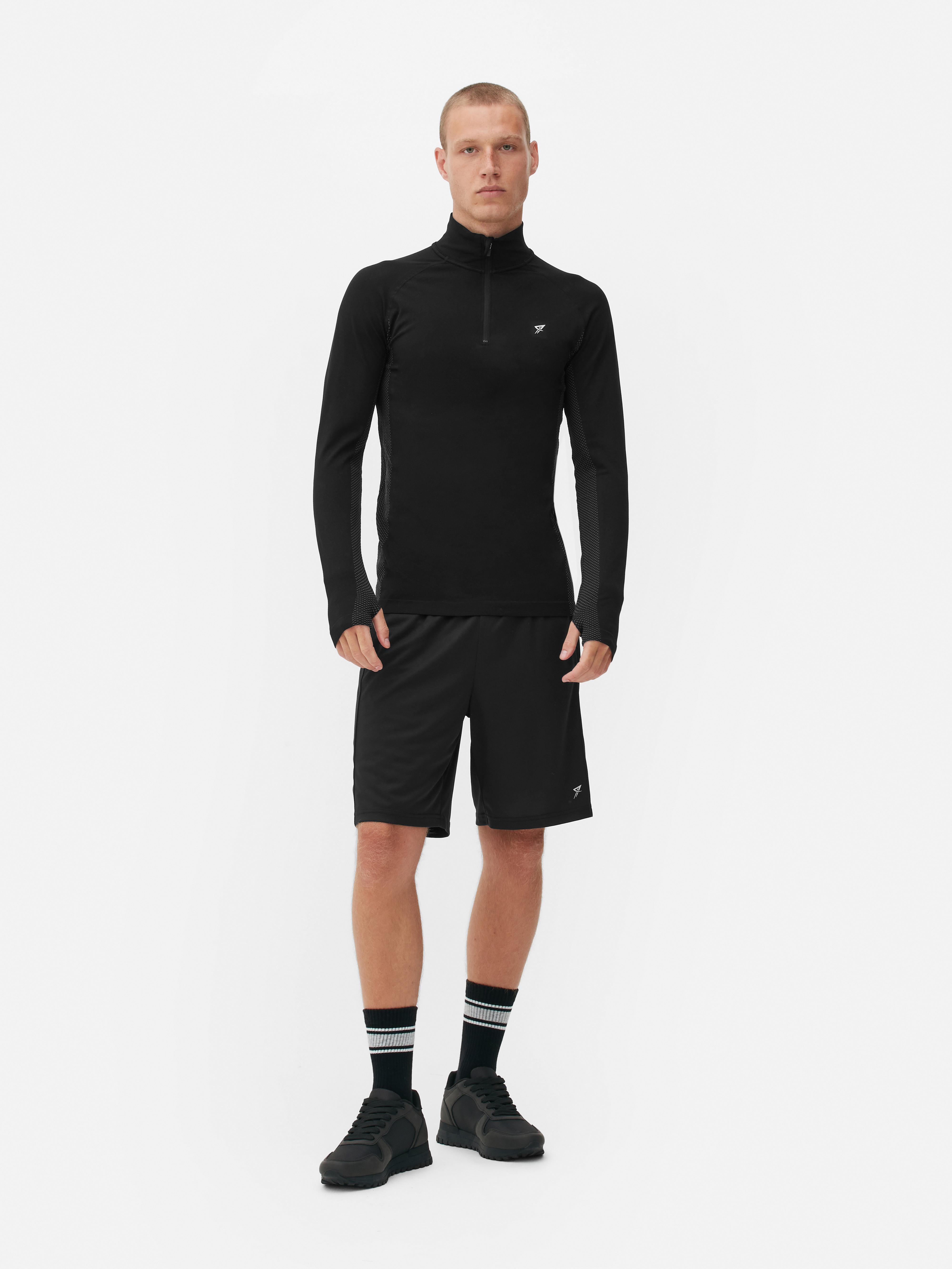 Top sport cu fermoar cu un sfert și mâneci lungi Un top sport cu mâneci lungi, guler ridicat, închidere cu fermoar cu un sfert și tiv drept