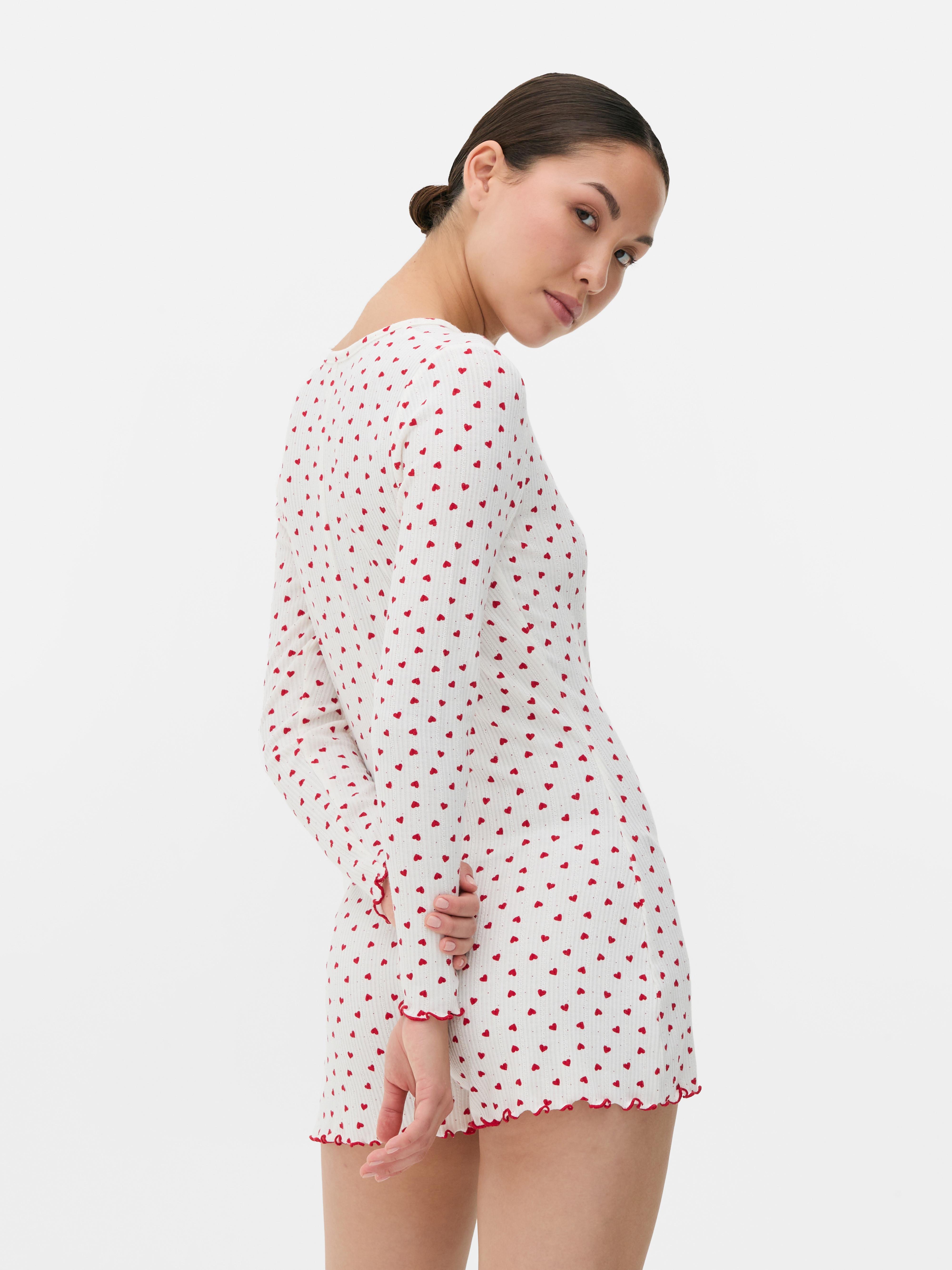 Salopetă de pijama cu model cu inimă. O salopetă de pijama confecționată din material moale cu nervuri, cu tiv festonat și model.