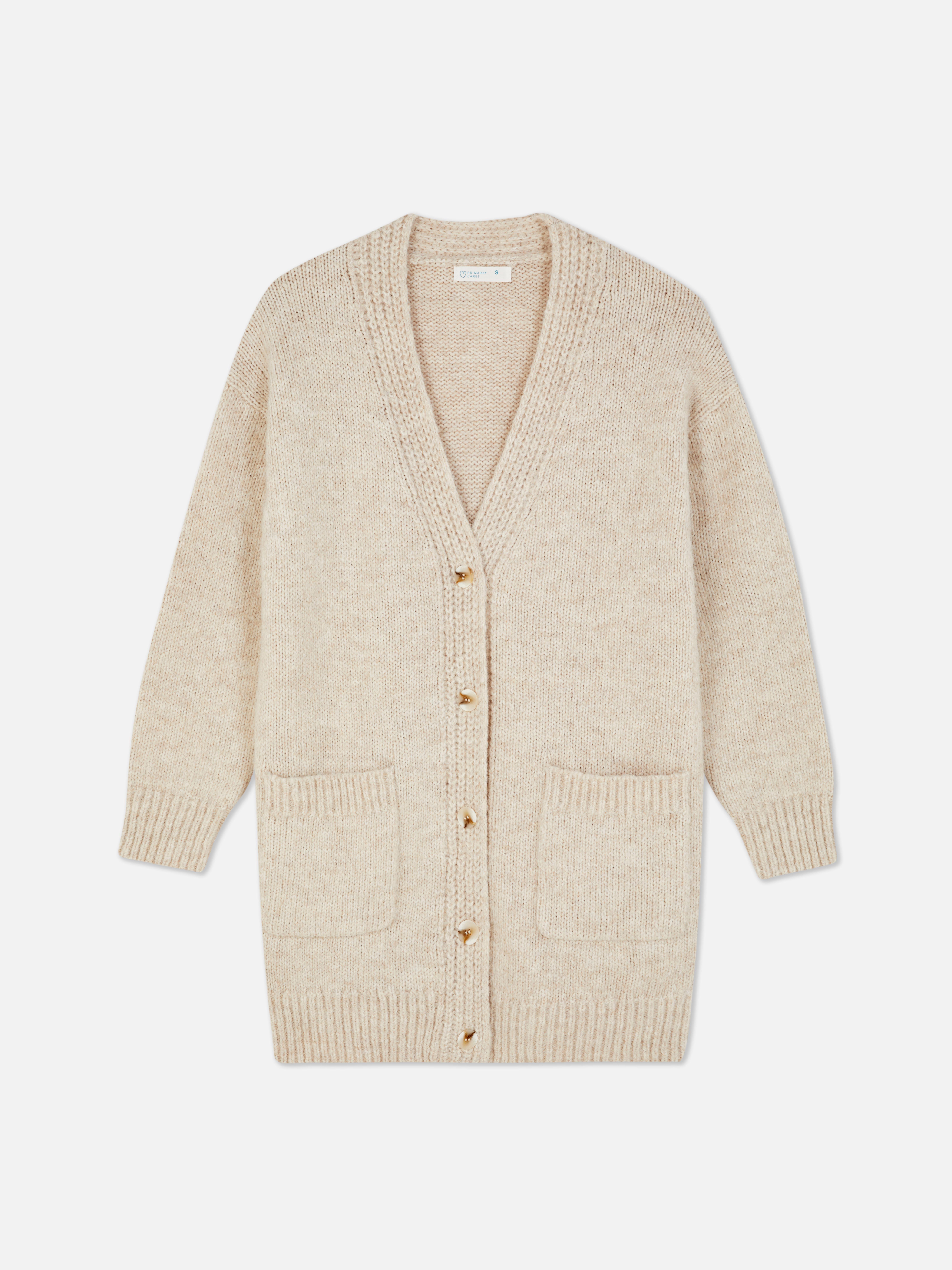 Oversize-Strickjacke. Eine lange Strickjacke mit Oversize-Schnitt, V-Ausschnitt und aufgesetzten Taschen.