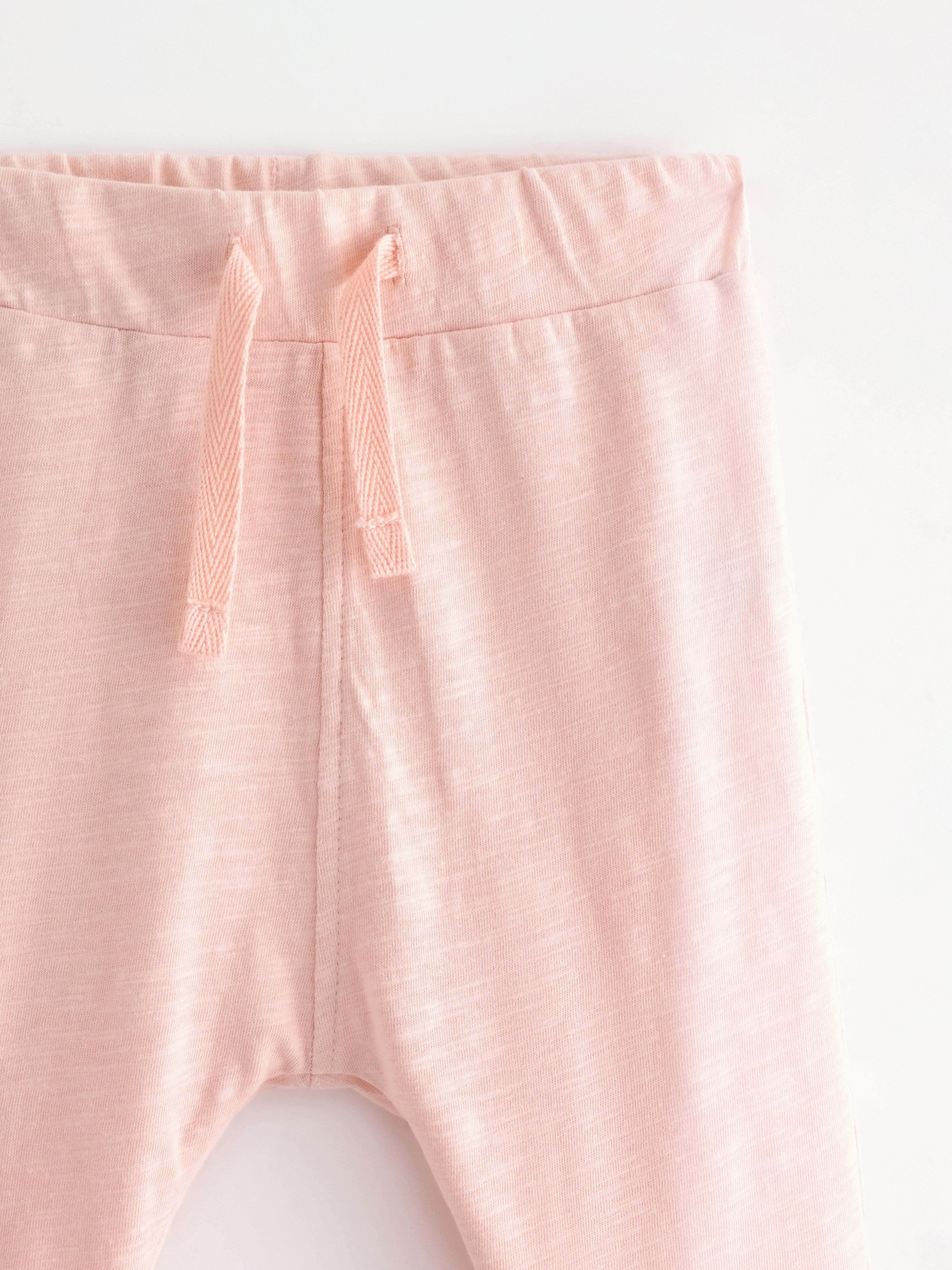 Pantalones deportivos de punto flameado, color rosa claro empolvado.