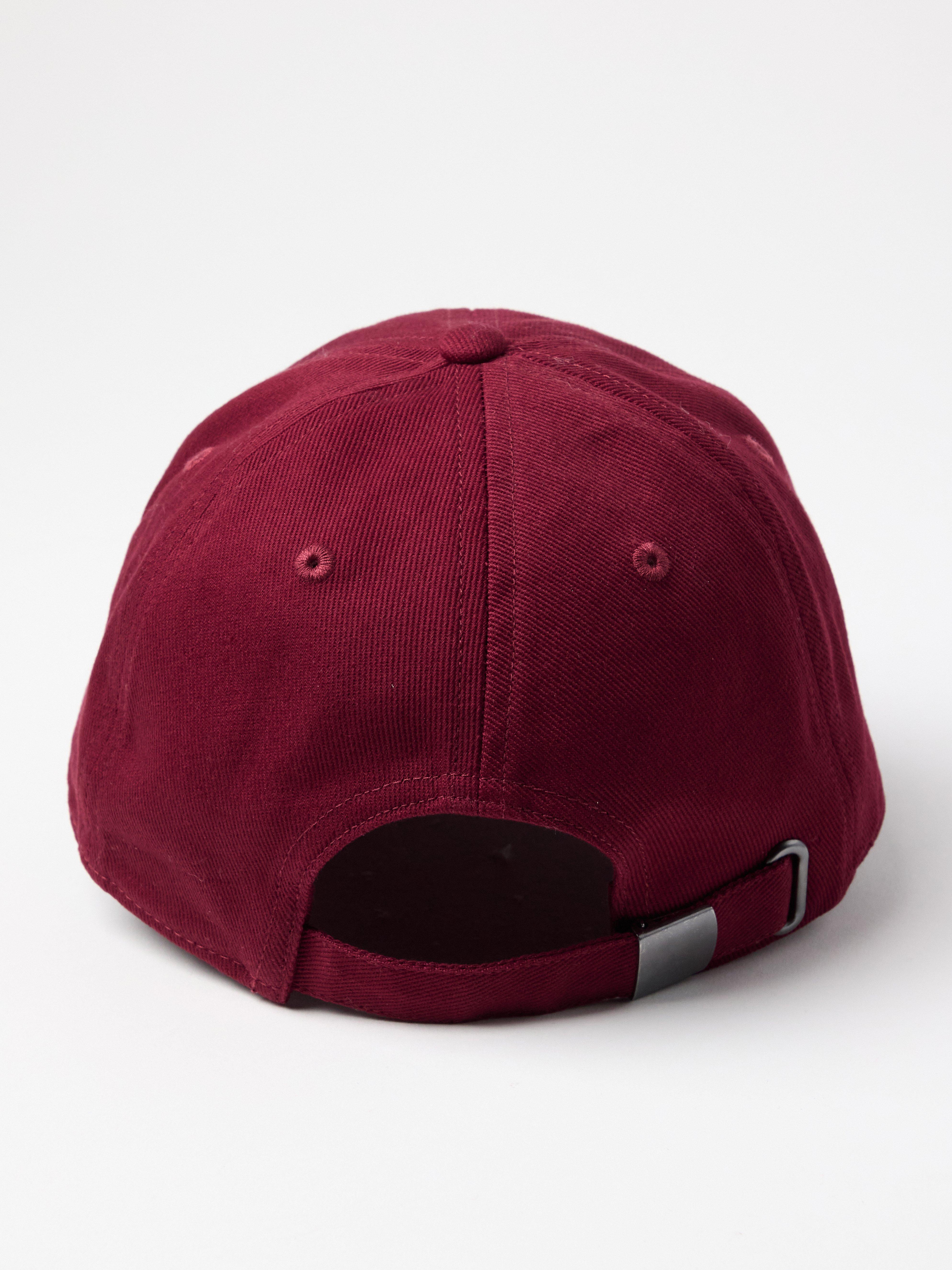 Gorra con visera redondeada, color rojo oscuro empolvado.