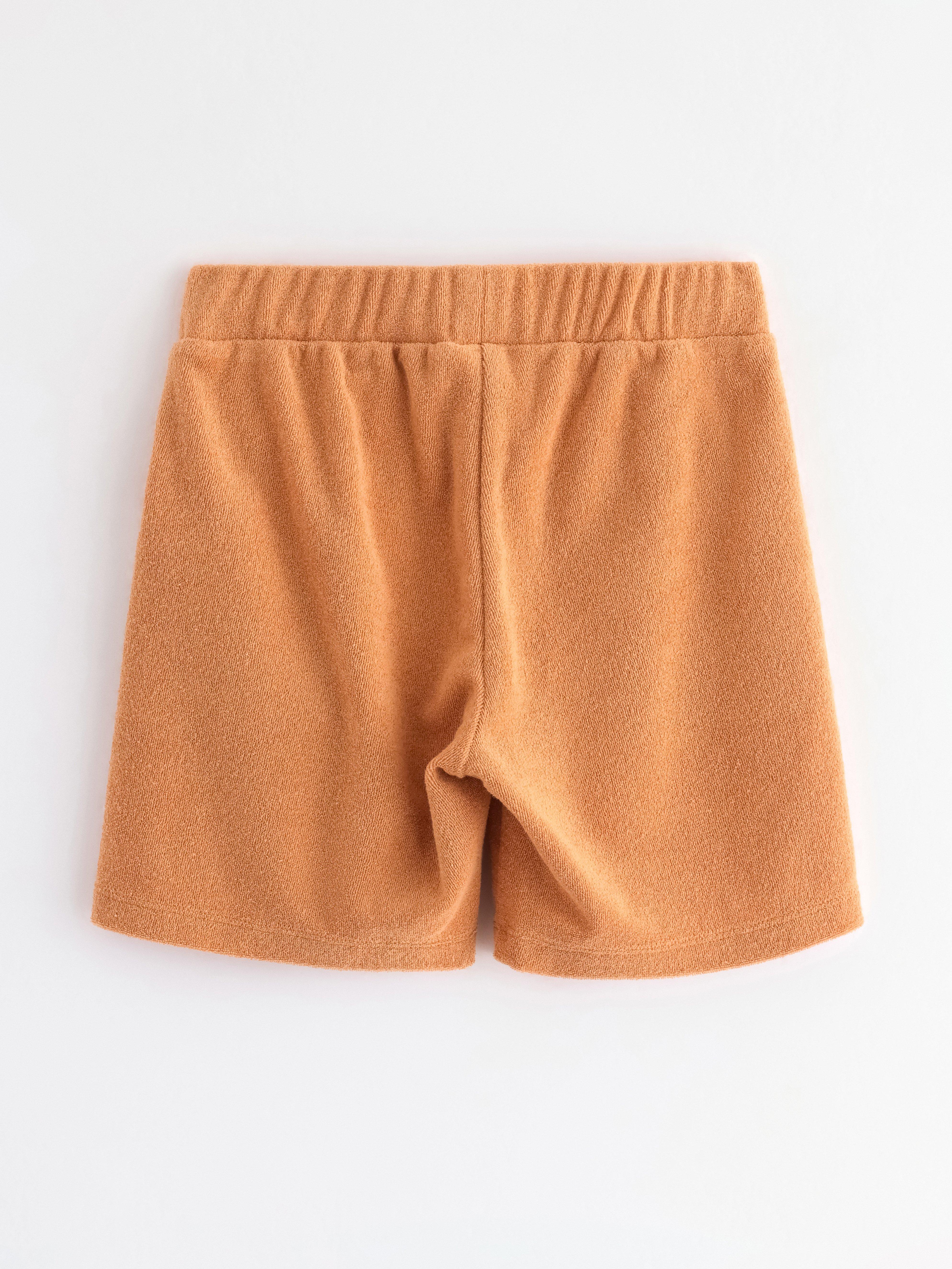 Pantalones cortos de color beige oscuro desgastado