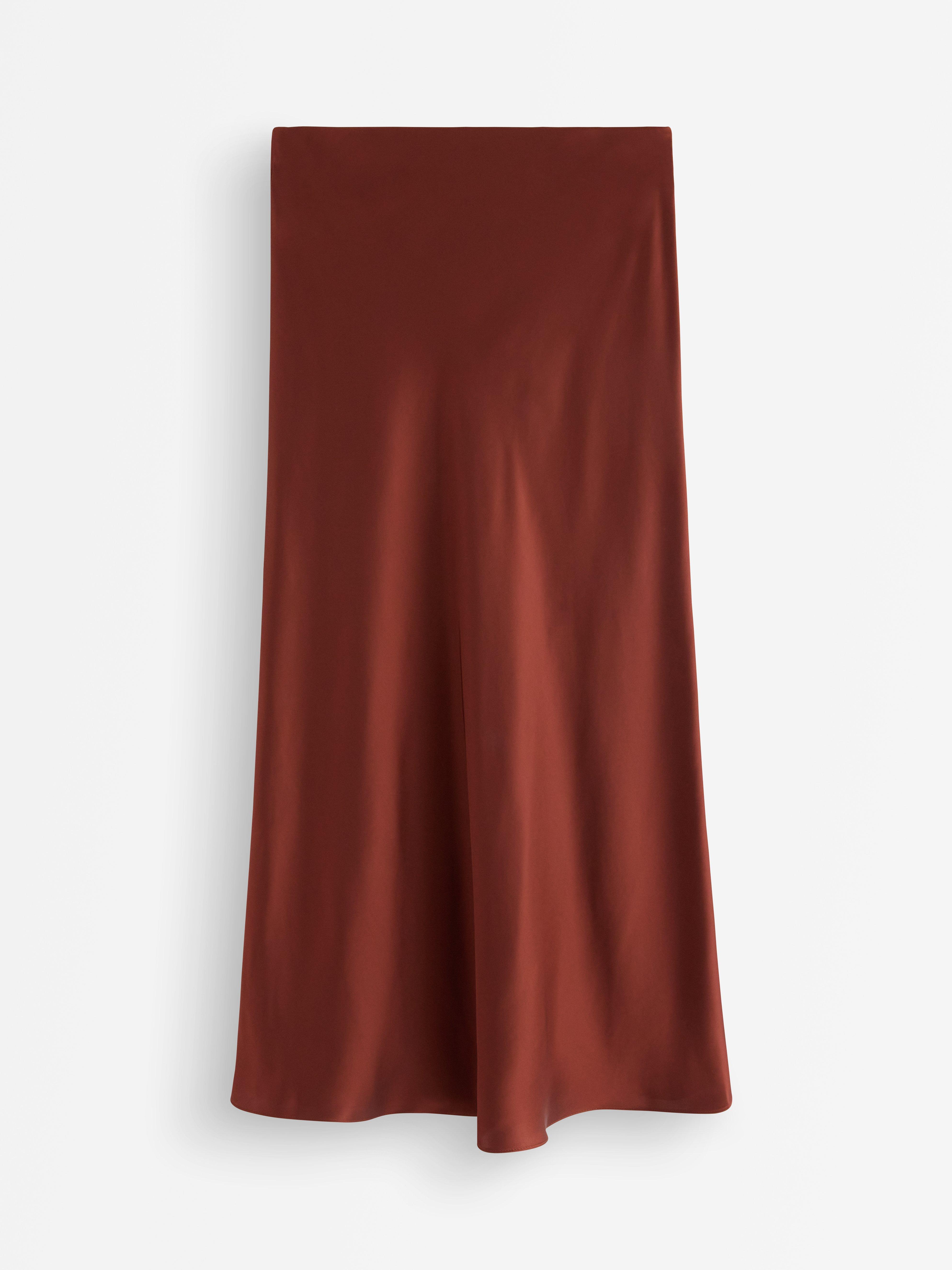 Falda midi de satén color rojo oscuro empolvado.