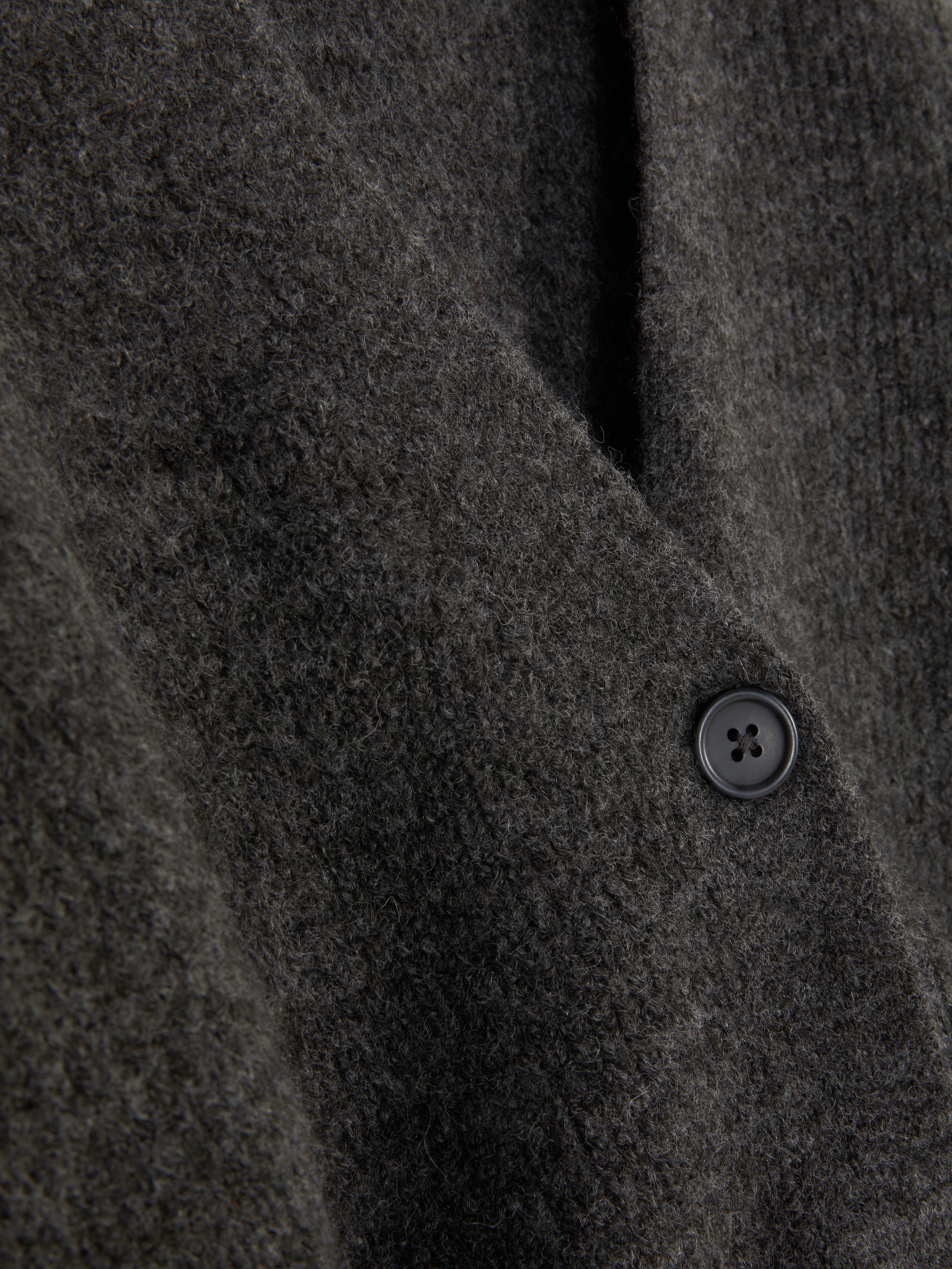 Cardigan con scollo a V e vestibilità comoda. Questo cardigan con bottoni, vestibilità comoda e spalle scese è un classico elegante.