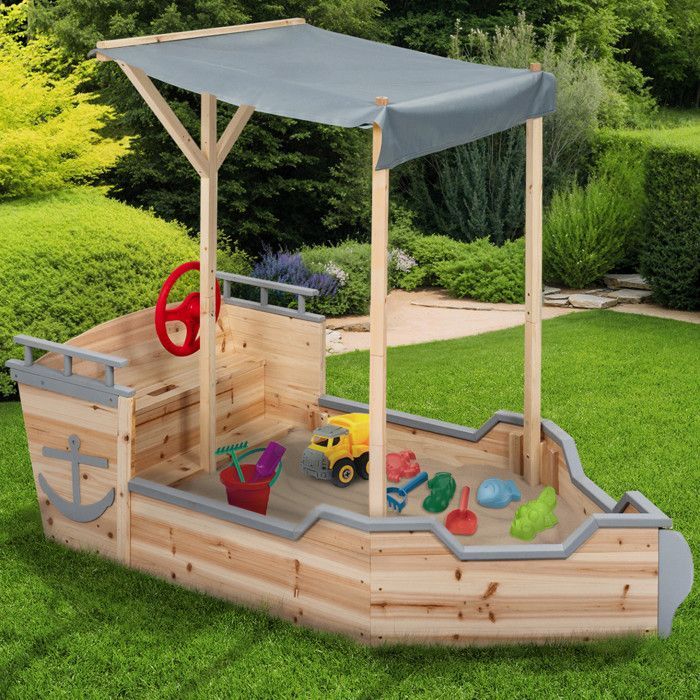 Arenero de madera con forma de barco pirata de IDMARKET WORLD con banco, caja de almacenamiento y techo gris.