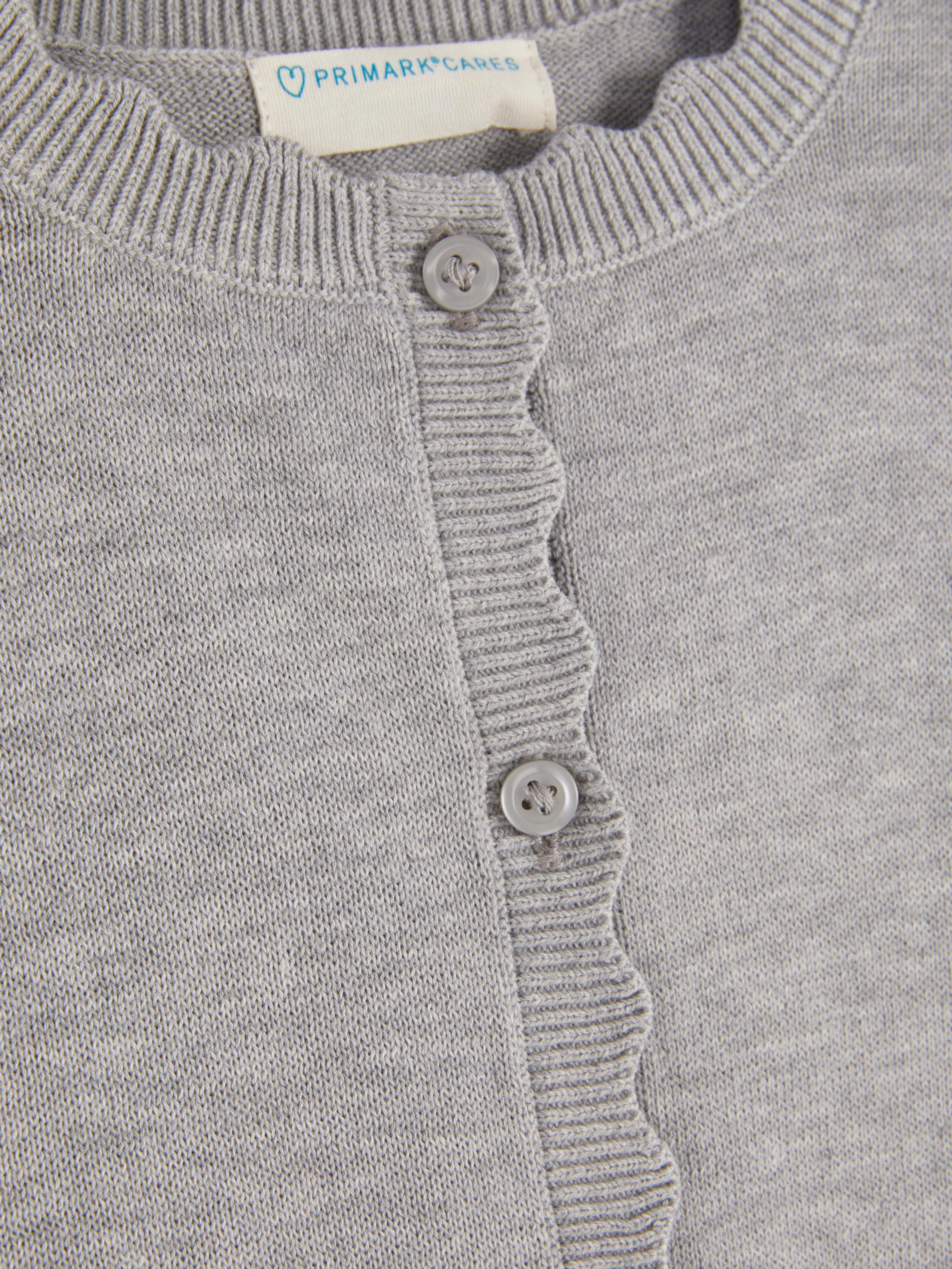 Cardigan with button closure and scalloped edge A cute cardigan with long sleeves, button closure, and scalloped edges
