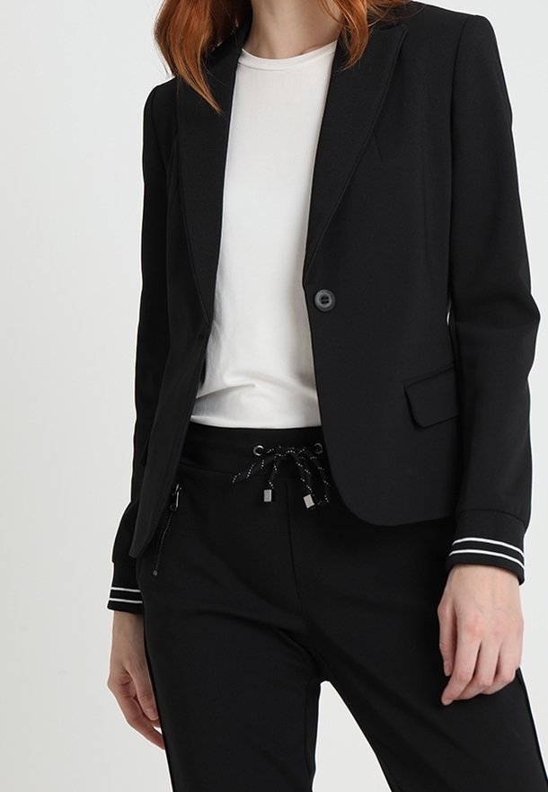 Blazer noir à l'identité décontractée.