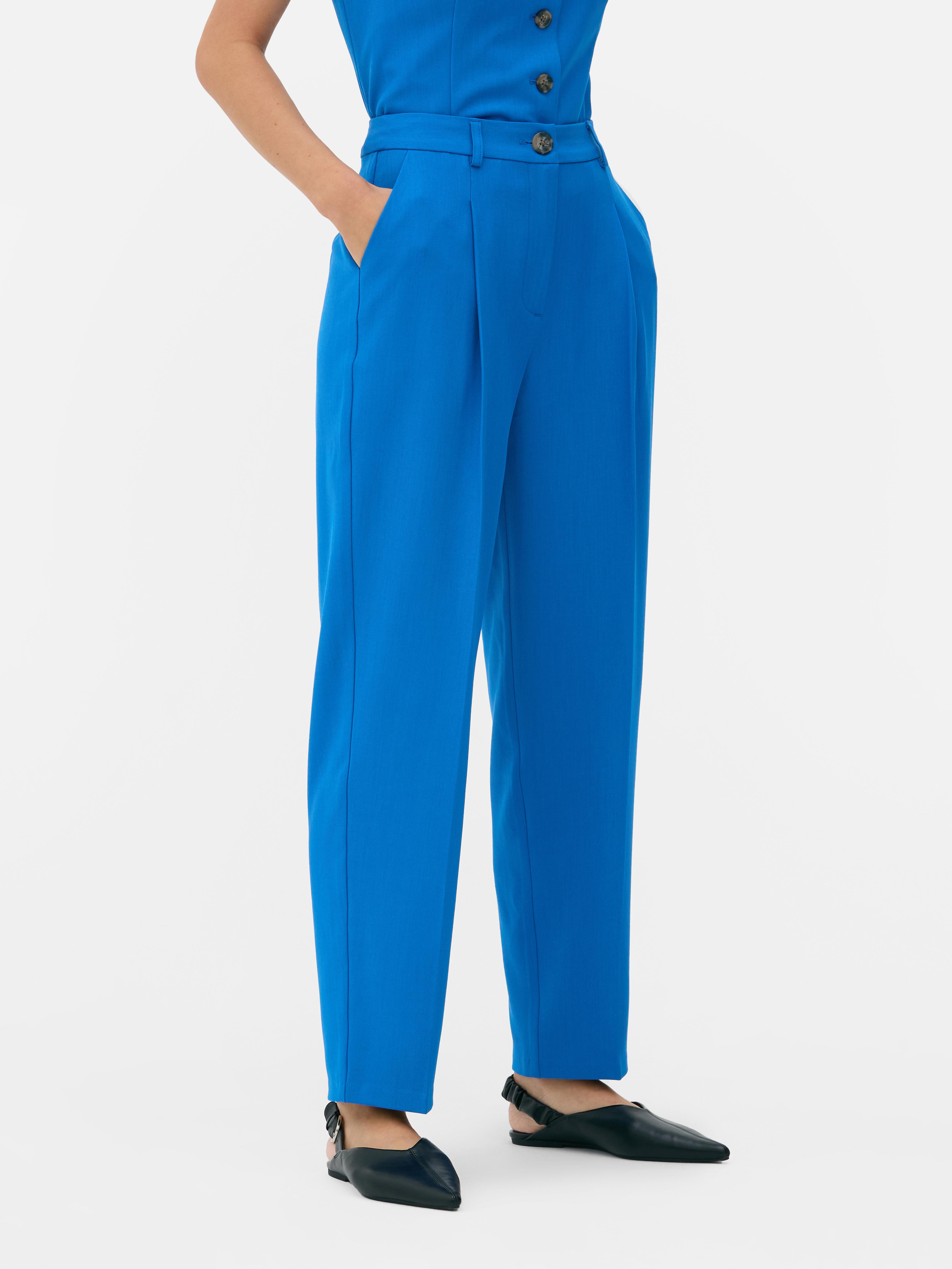 Passende Hose mit geradem Bein. Eine minimalistische Hose mit Bundfalten, geradem Schnitt und neutraler Farbe.
