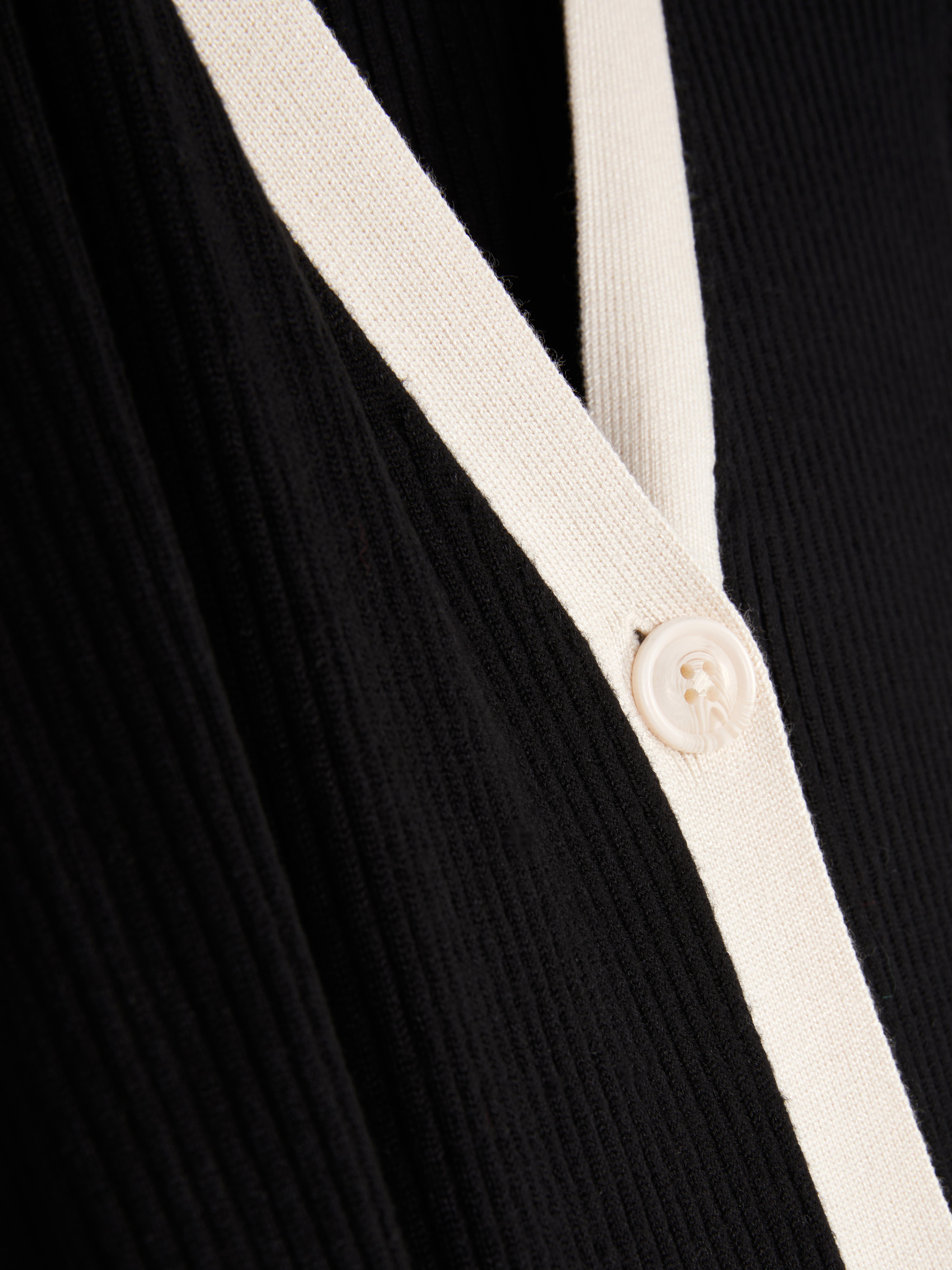 Abito cardigan a coste. Abito cardigan midi realizzato in tessuto a coste con chiusura a bottoni e bordi a contrasto.
