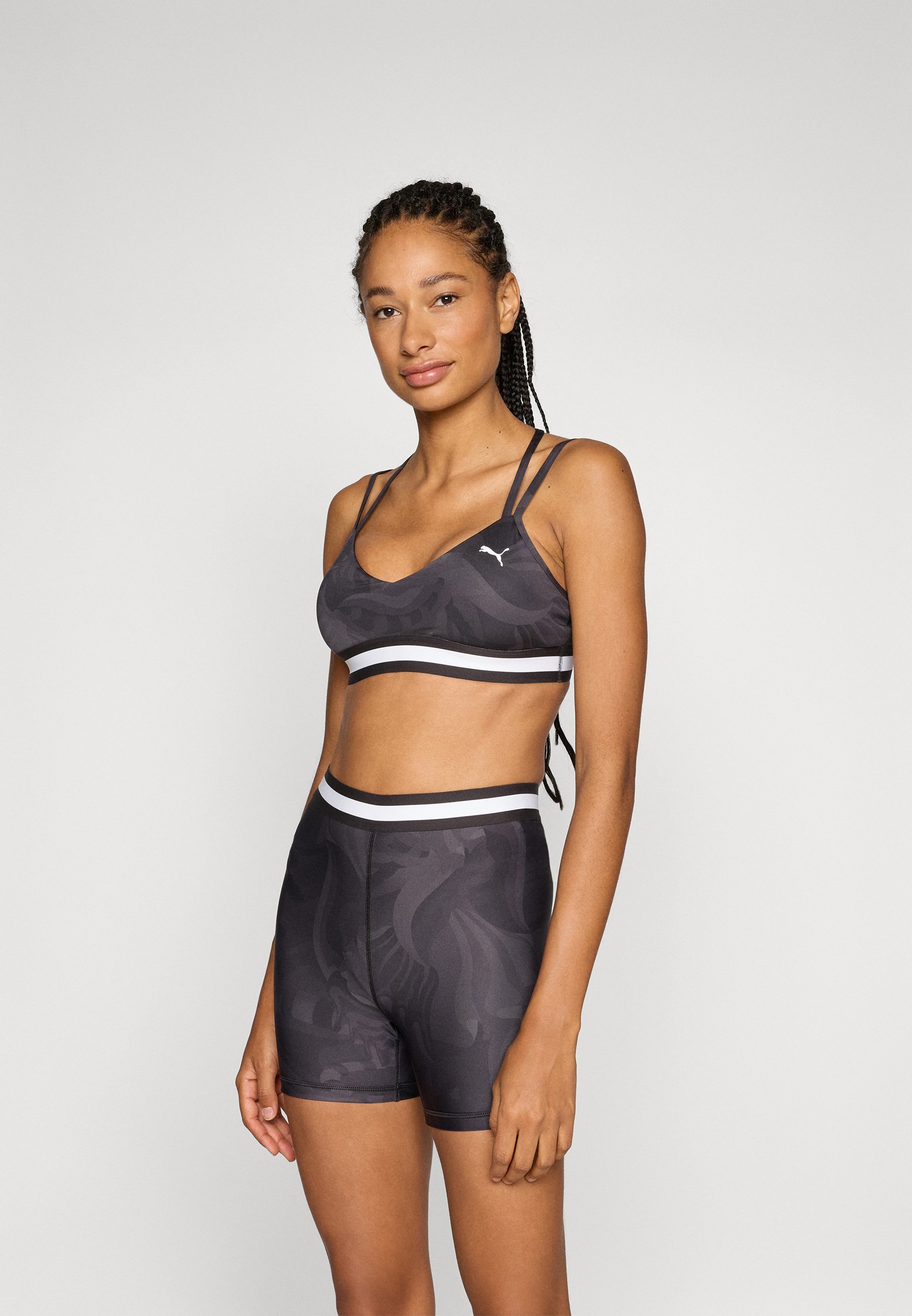 Soutien-gorge de sport à bretelles fines et à ruban floral Puma - Maintien léger - Noir