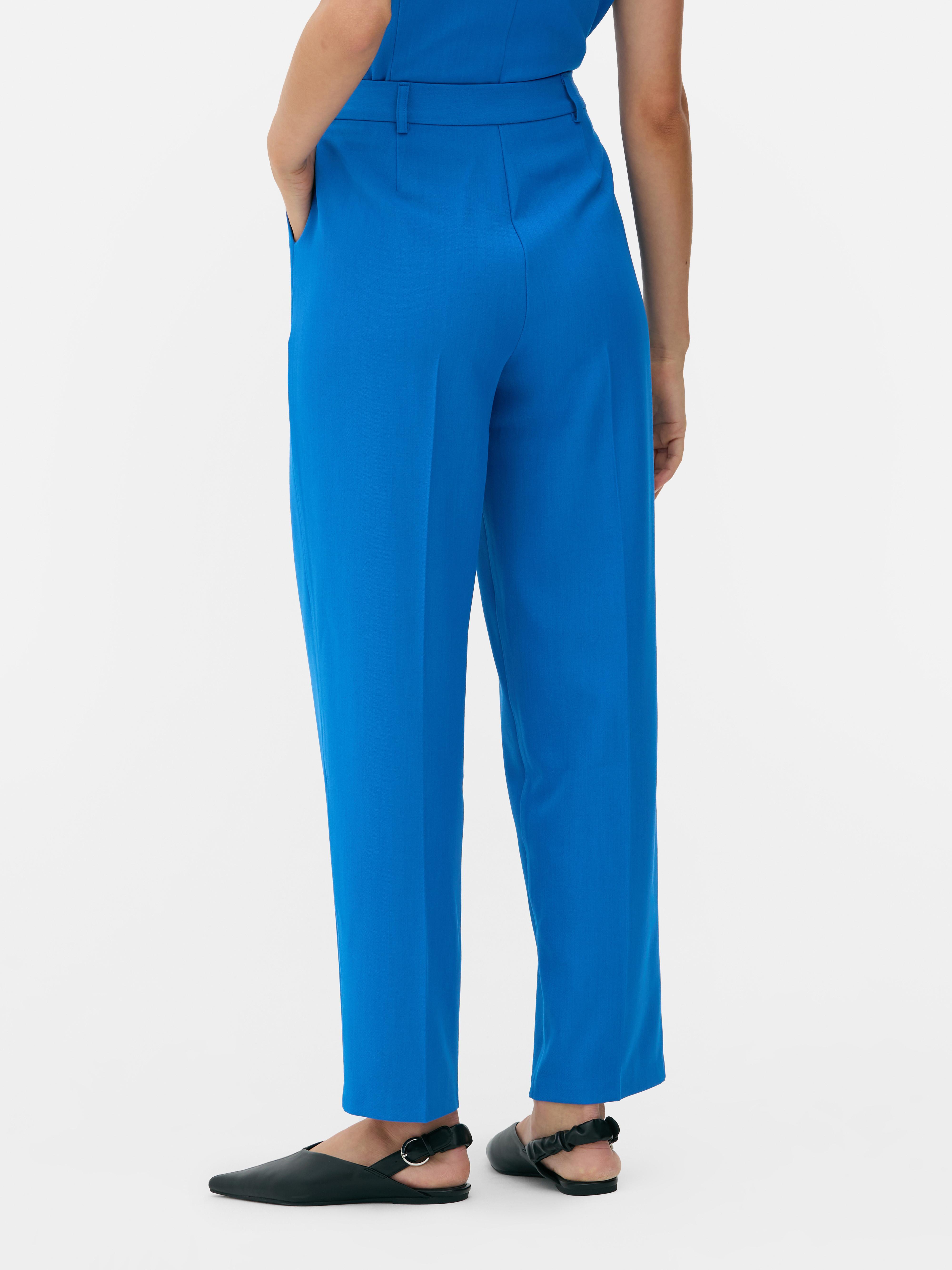 Passende Hose mit geradem Bein. Eine minimalistische Hose mit Bundfalten, geradem Schnitt und neutraler Farbe.
