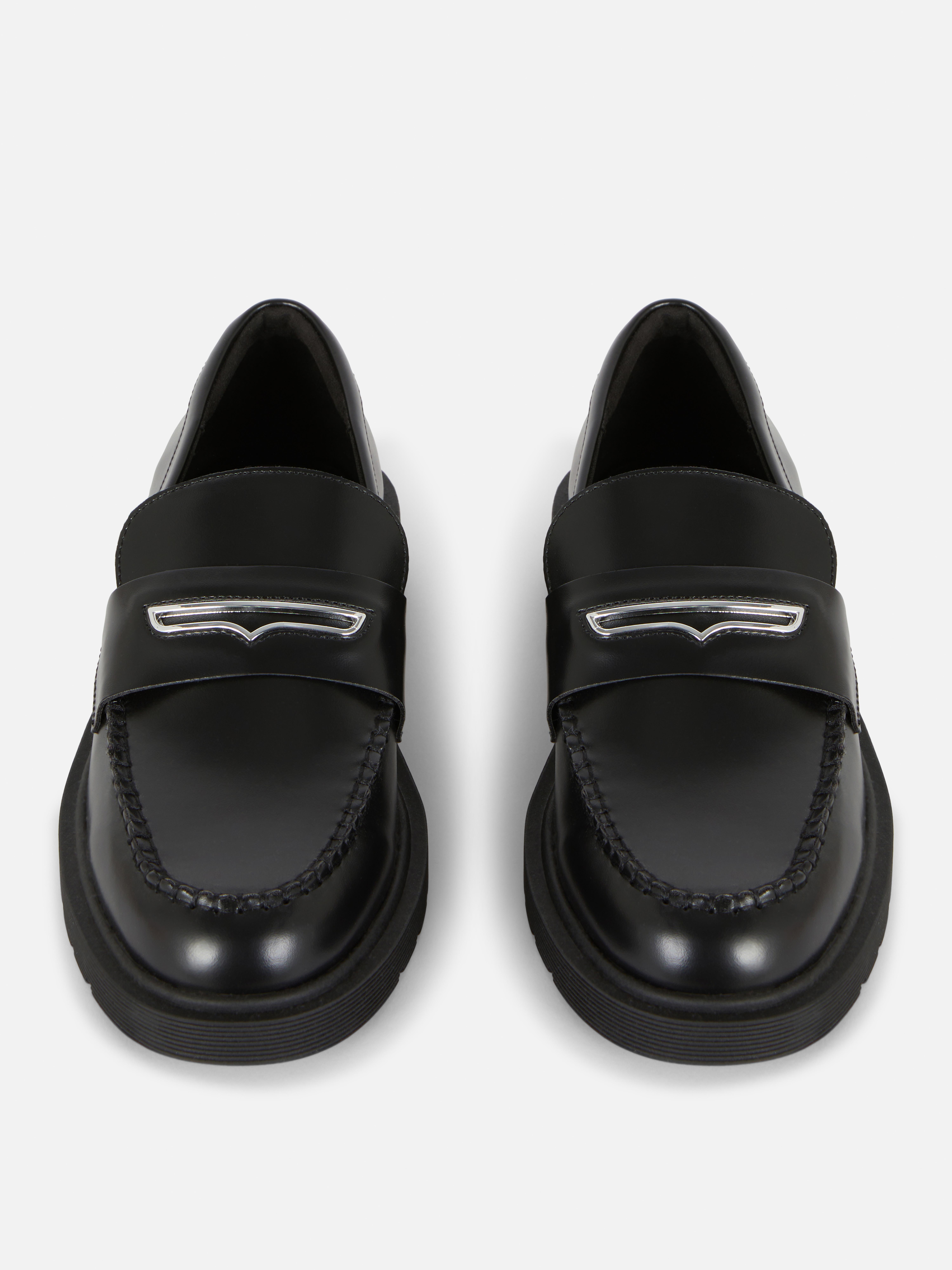 Mocasini lați cu detalii metalice O pereche de mocasini cu o croială largă și decorațiuni metalice în partea de sus