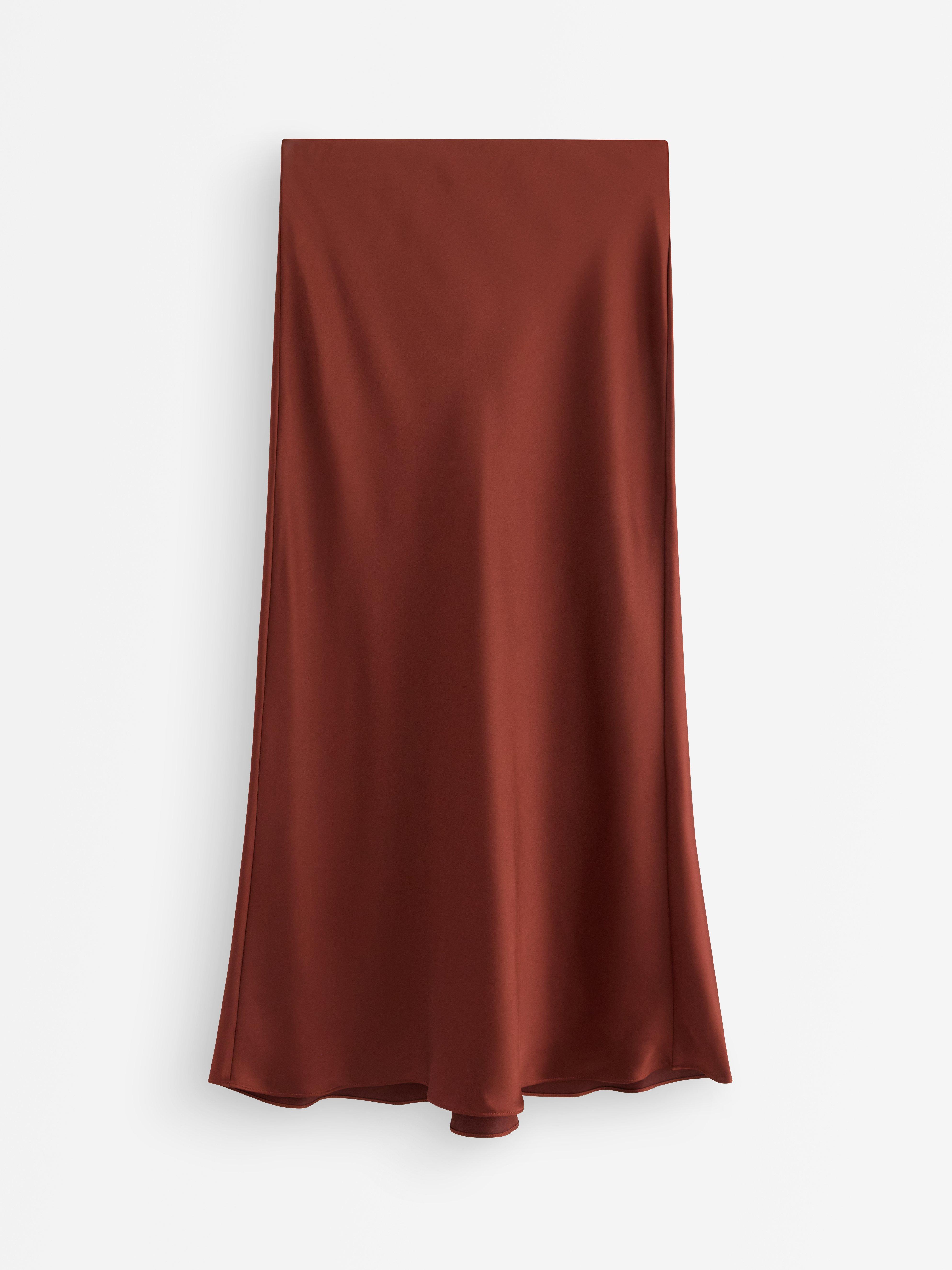 Falda midi de satén color rojo oscuro empolvado.