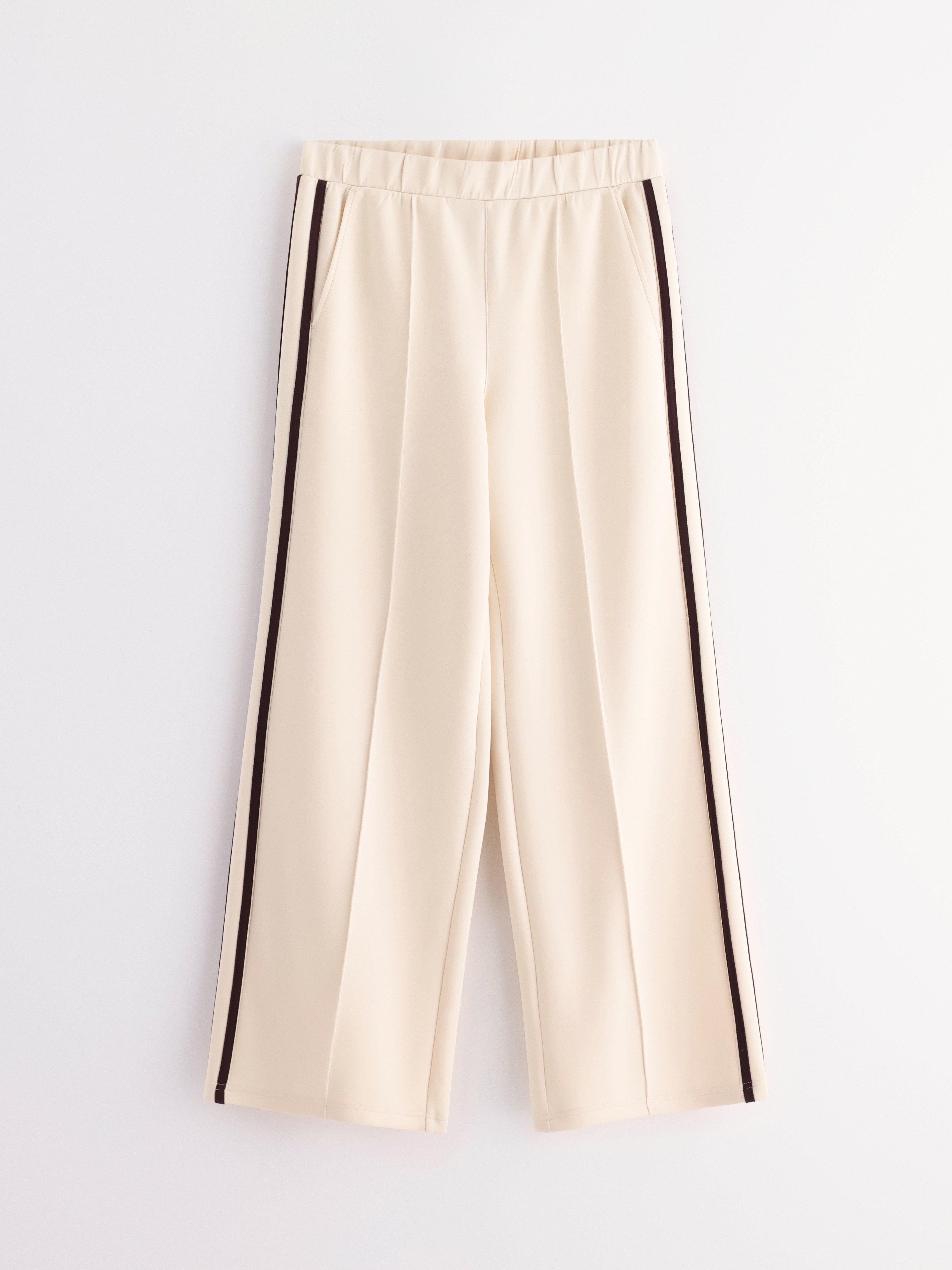 Pantalones anchos de punto color beige claro.