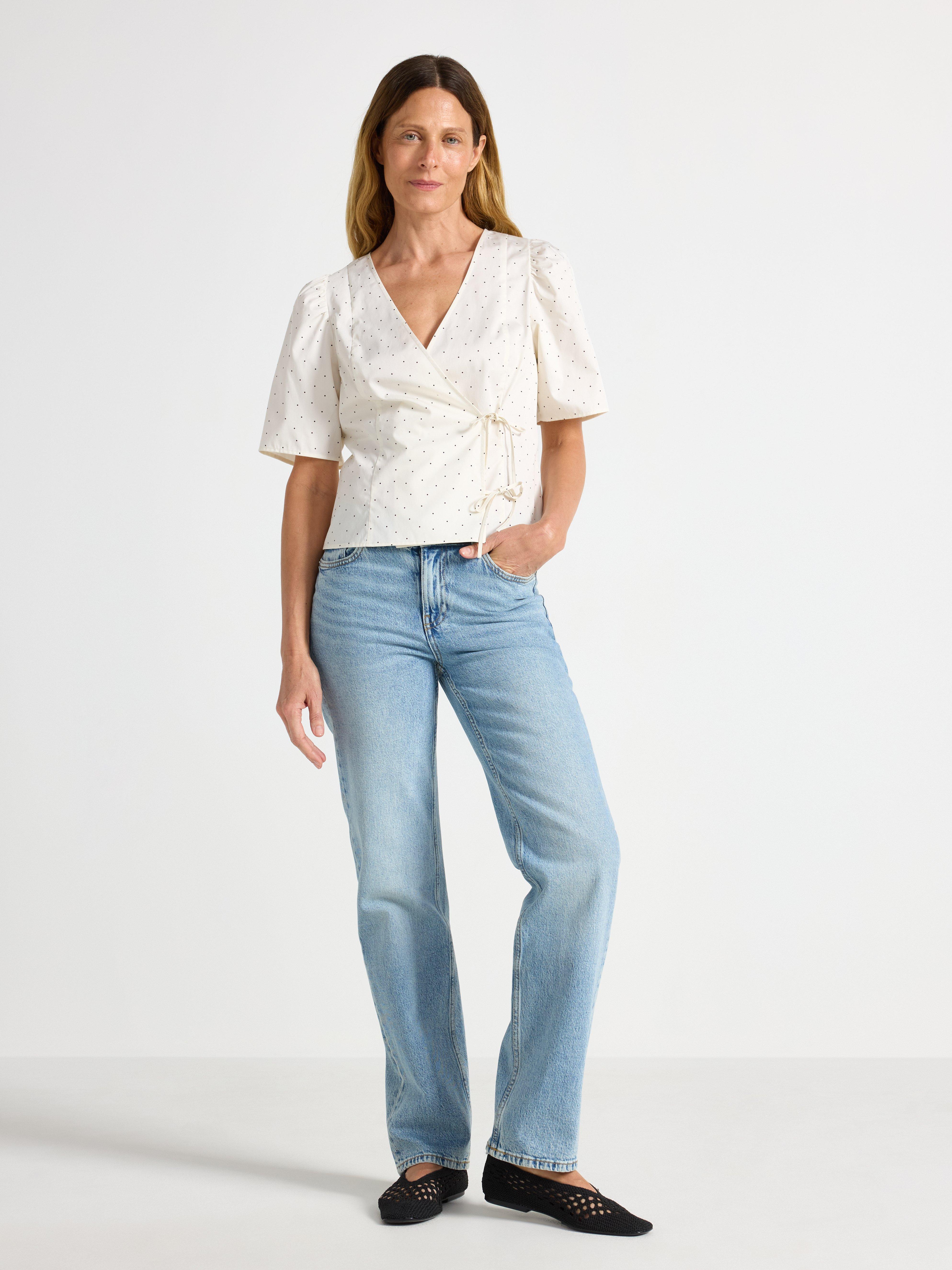 Blusa con diseño cruzado, color blanco claro.