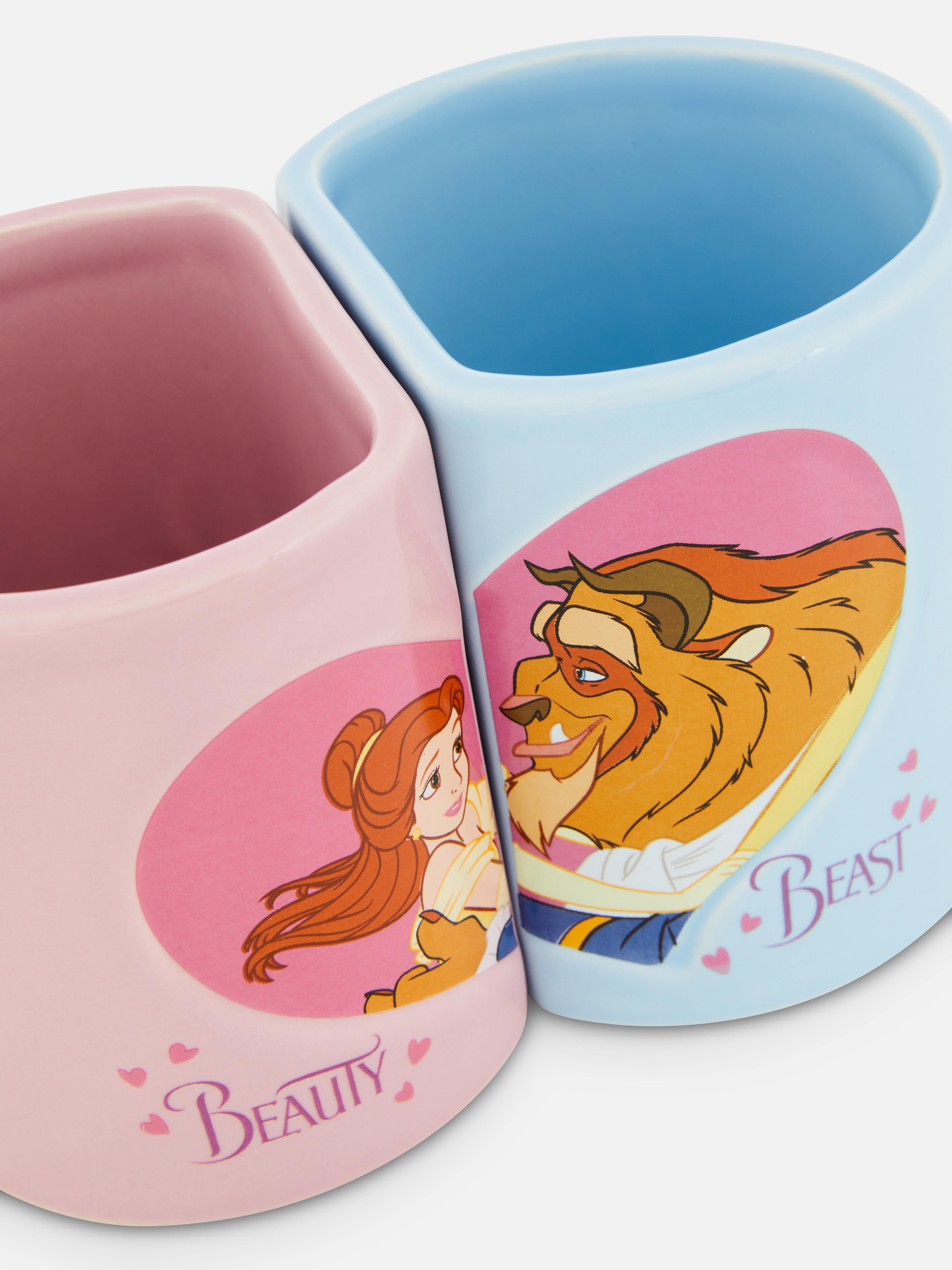 Căni Disney Frumoasa și Bestia cu mânere, set de 2. Două căni Frumoasa și Bestia cu mânere în formă de inimă, livrate într-o cutie cadou.