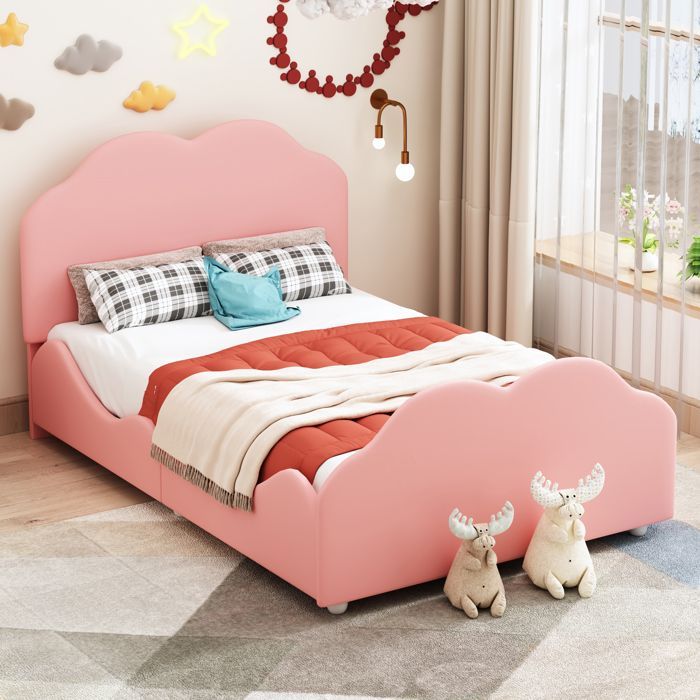 Cama infantil tapizada de 90x200 cm en terciopelo rosa con barandilla de seguridad y cabecero en forma de nube; base de láminas incluida.