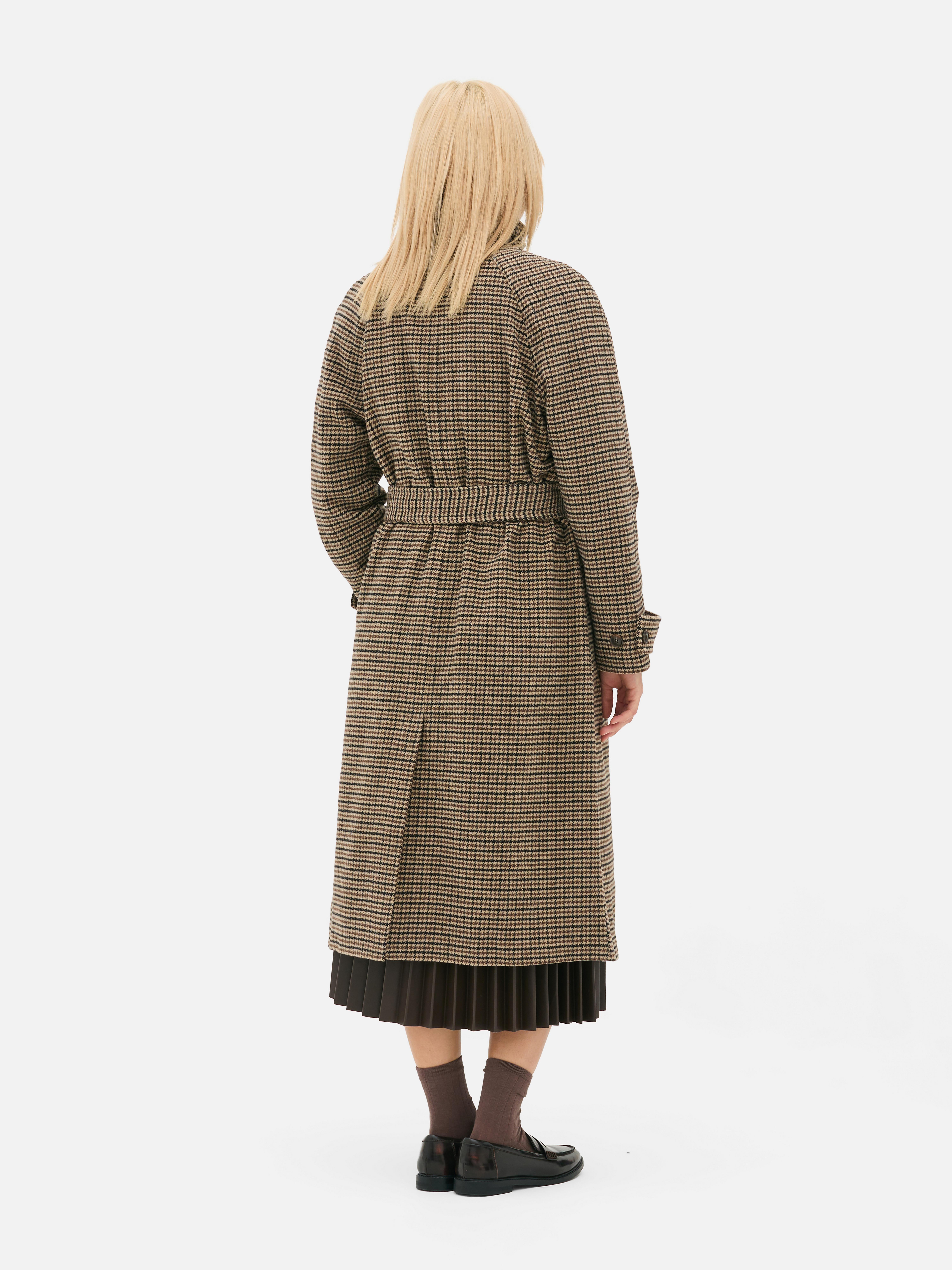 Palton cu guler ridicat și model în formă de picior de câine. Acest palton are o curea în talie, buzunare laterale și închidere cu nasturi în față.