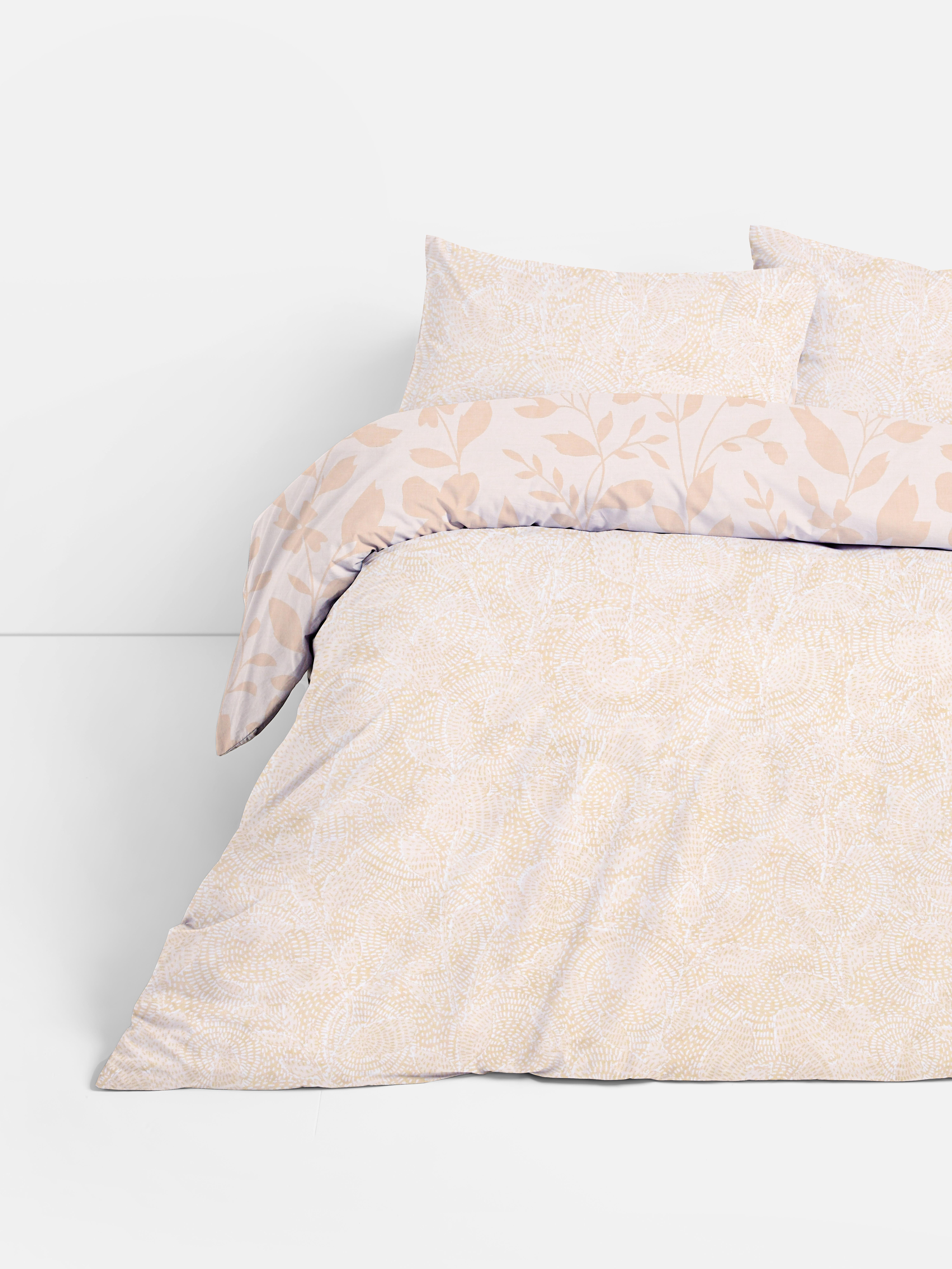Set de husă de pilotă dublă cu model floral reversibil. O husă de pilotă dublă cu un design floral și geometric.