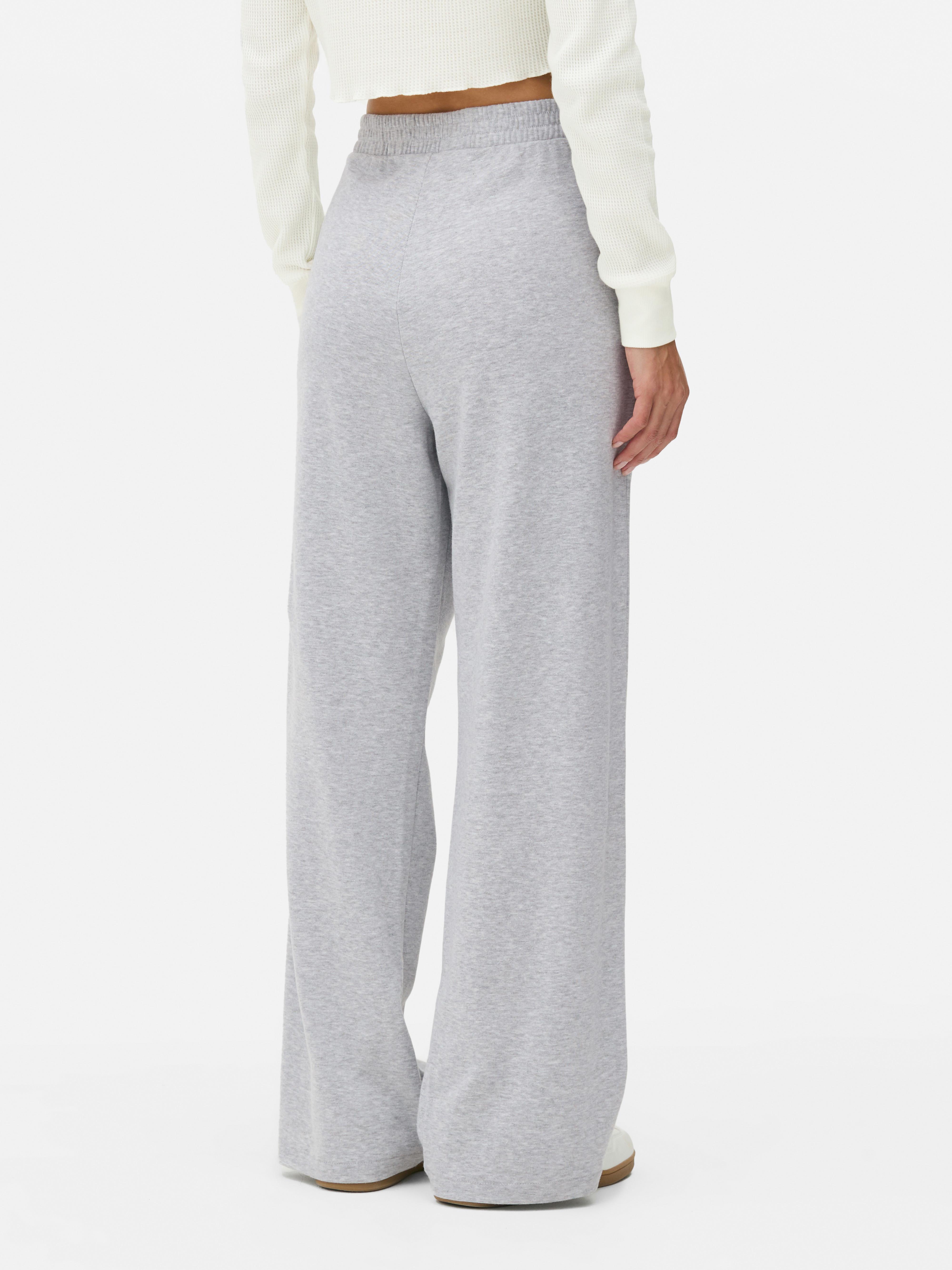 Pantaloni de trening din jerseu mulați. Acești pantaloni de trening au o fentă vizibilă cu nasturi și o siluetă elegantă.