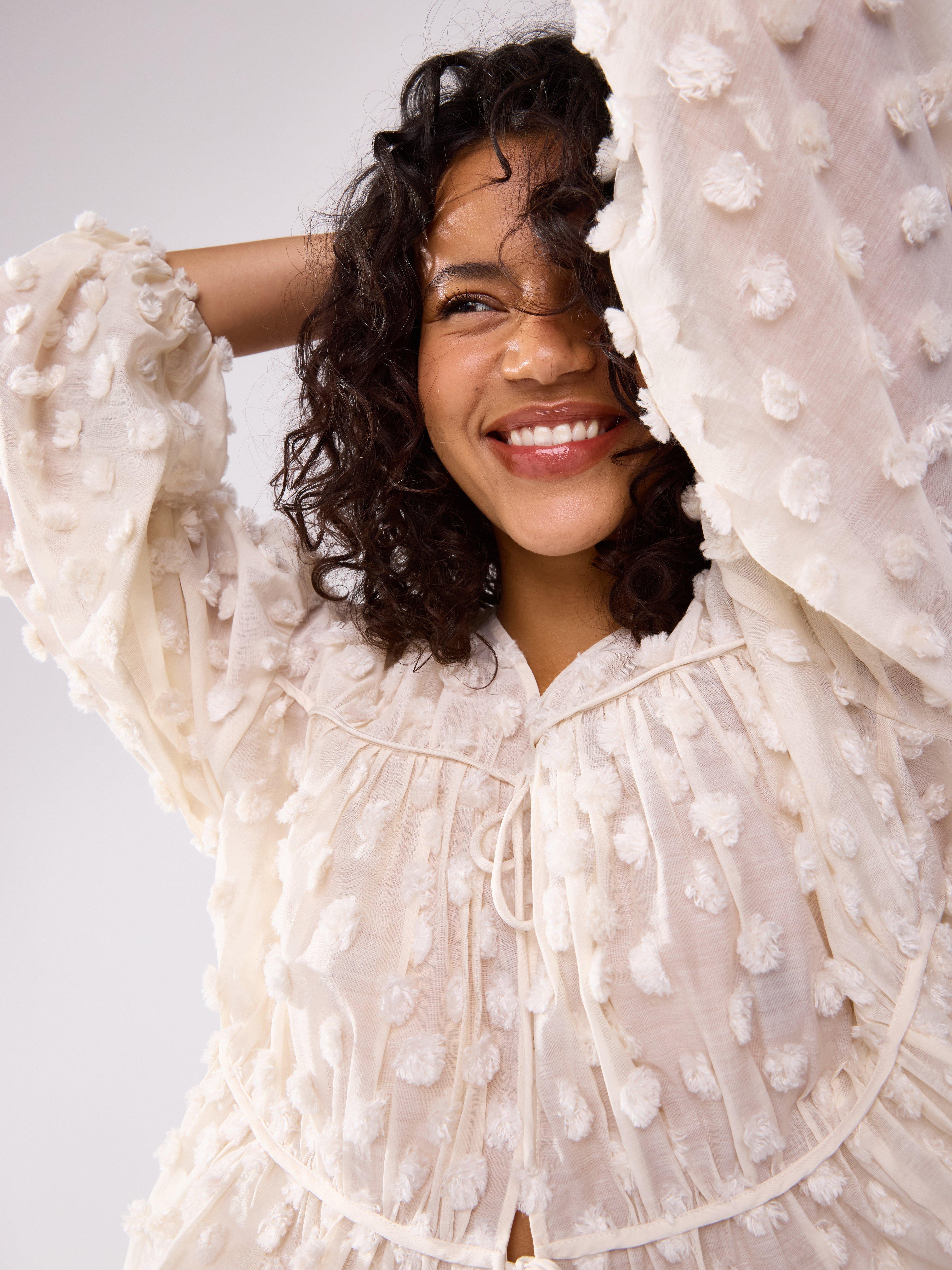 Blusa con lunares esponjosos, color beige claro.