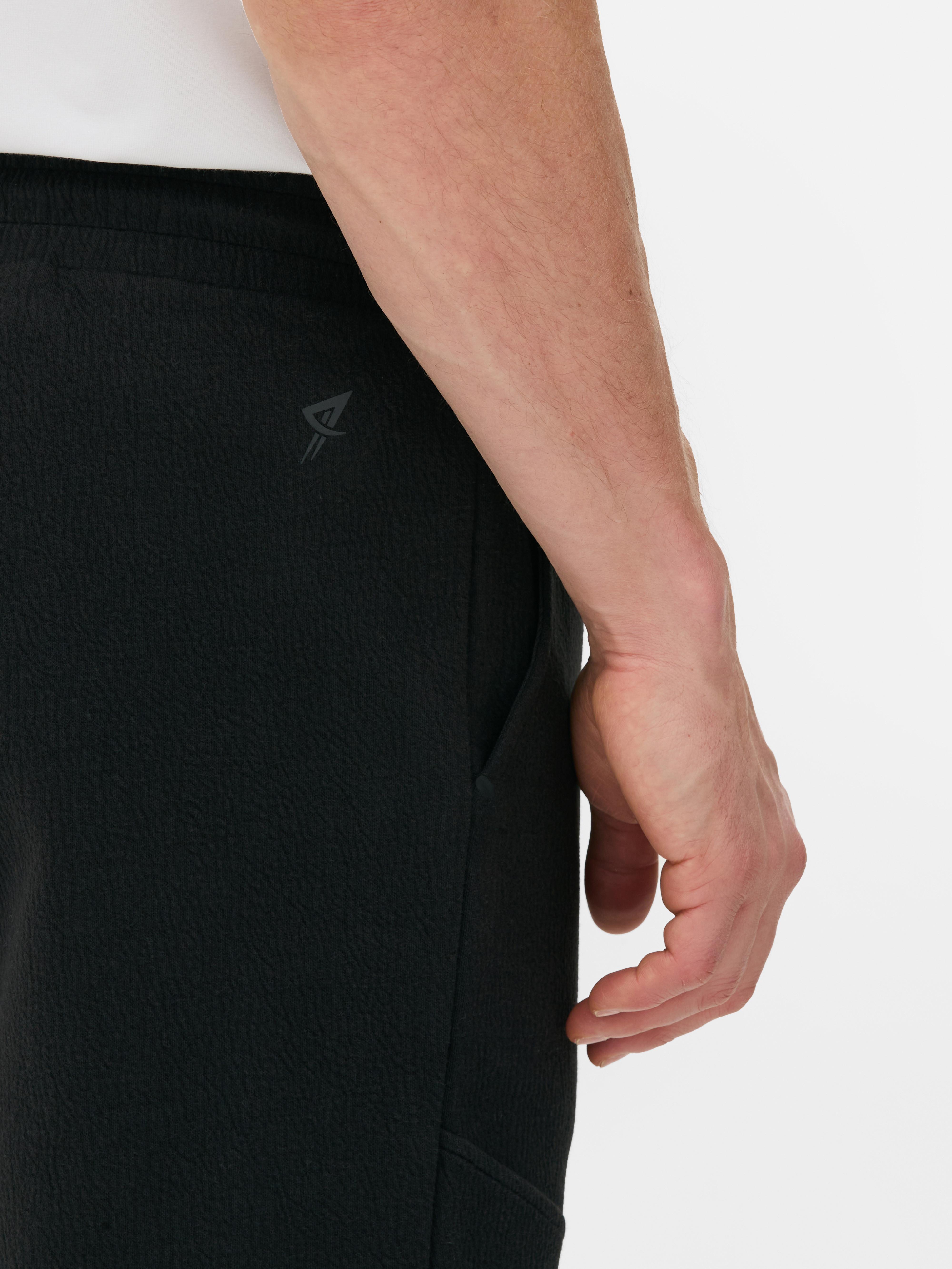 Pantaloni de trening texturați cu șnur de strângere Pantaloni de trening cu șnur de strângere, buzunare laterale, clinuri și manșete la gleznă