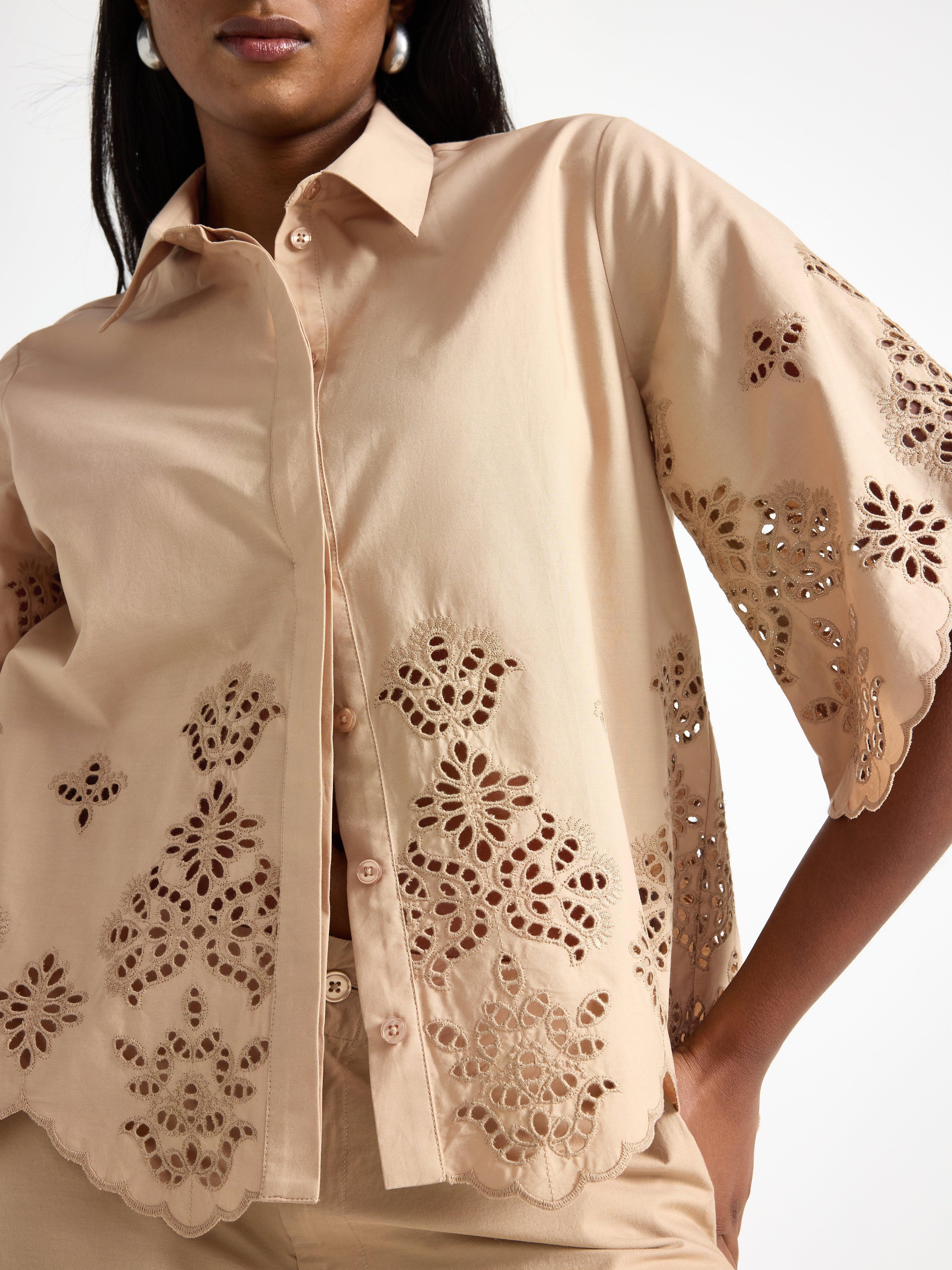 Camisa de manga curta bege com bordado.