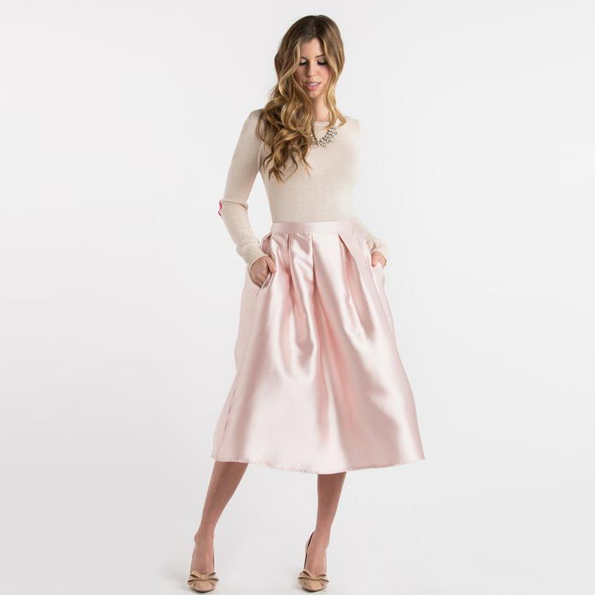 Jupe midi rose vif en satin pour femme, confectionnée sur mesure avec fermeture éclair à la taille, coupe trapèze, longueur mi-mollet, poches et plis.