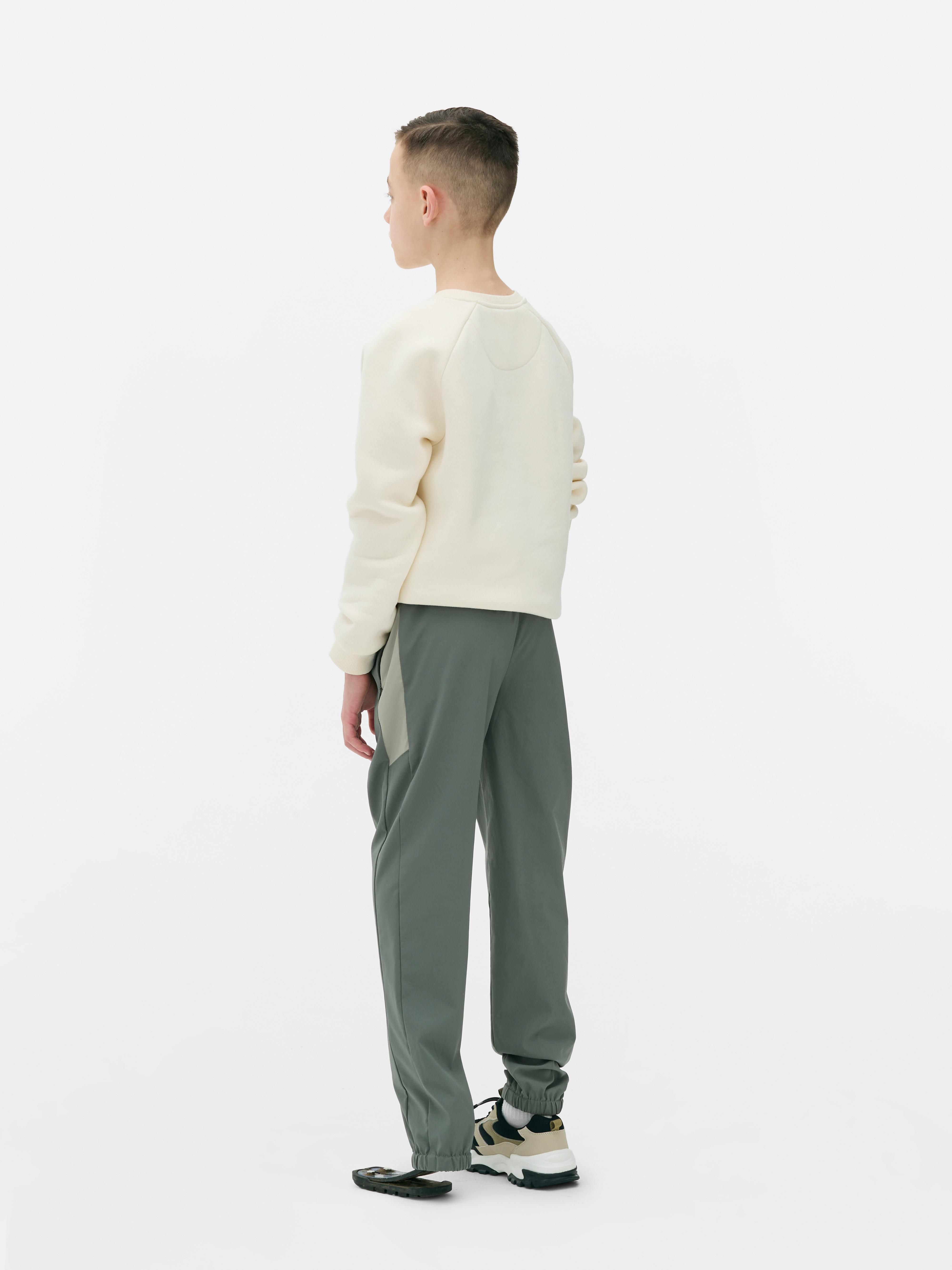 Pantaloni sport de jogging cu talie conică. Pantaloni de jogging cu talie cu șnur, buzunare cu fermoar și manșete la gleznă.