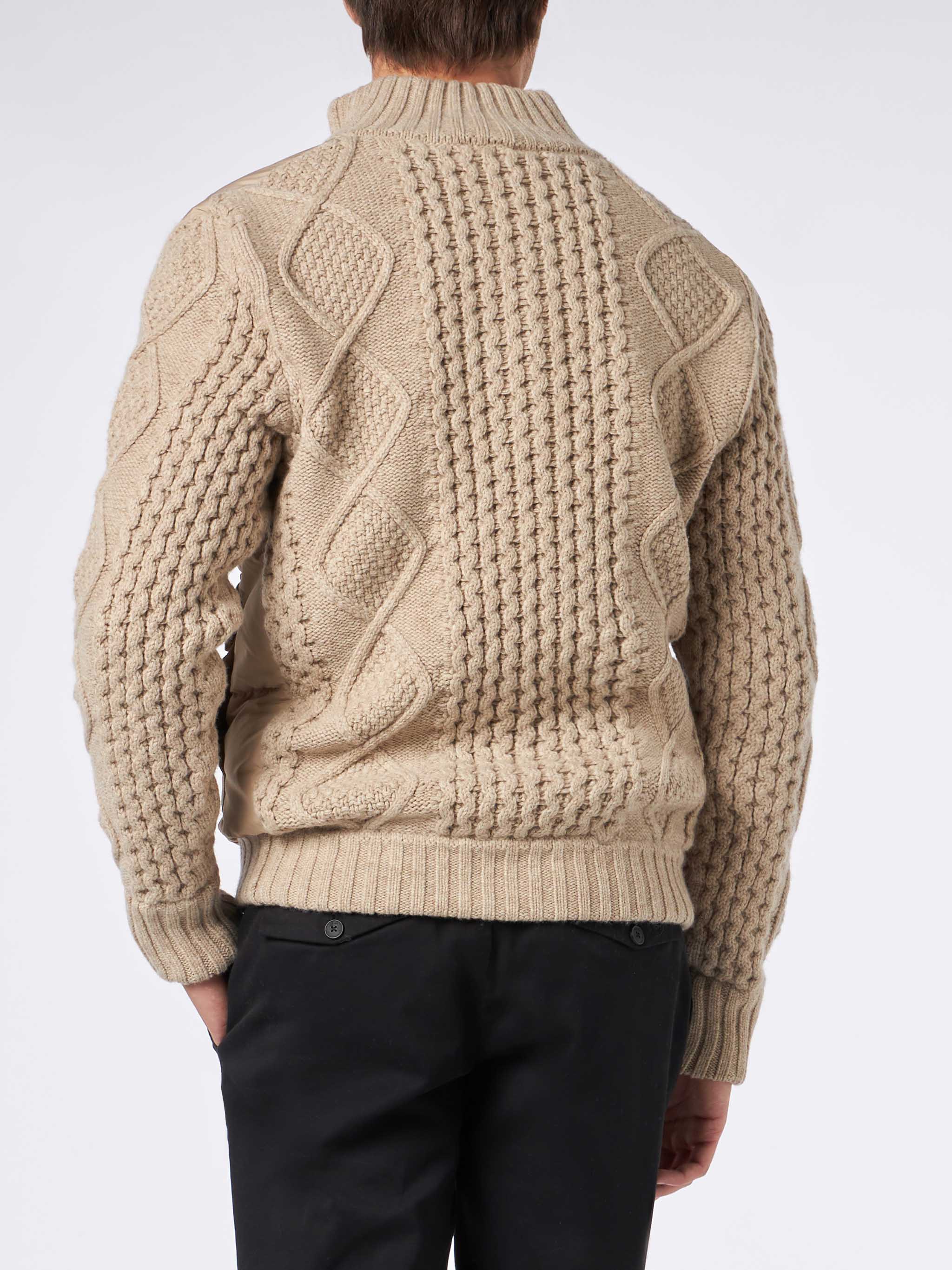 Chaqueta acolchada beige para hombre con mangas de punto tejido.