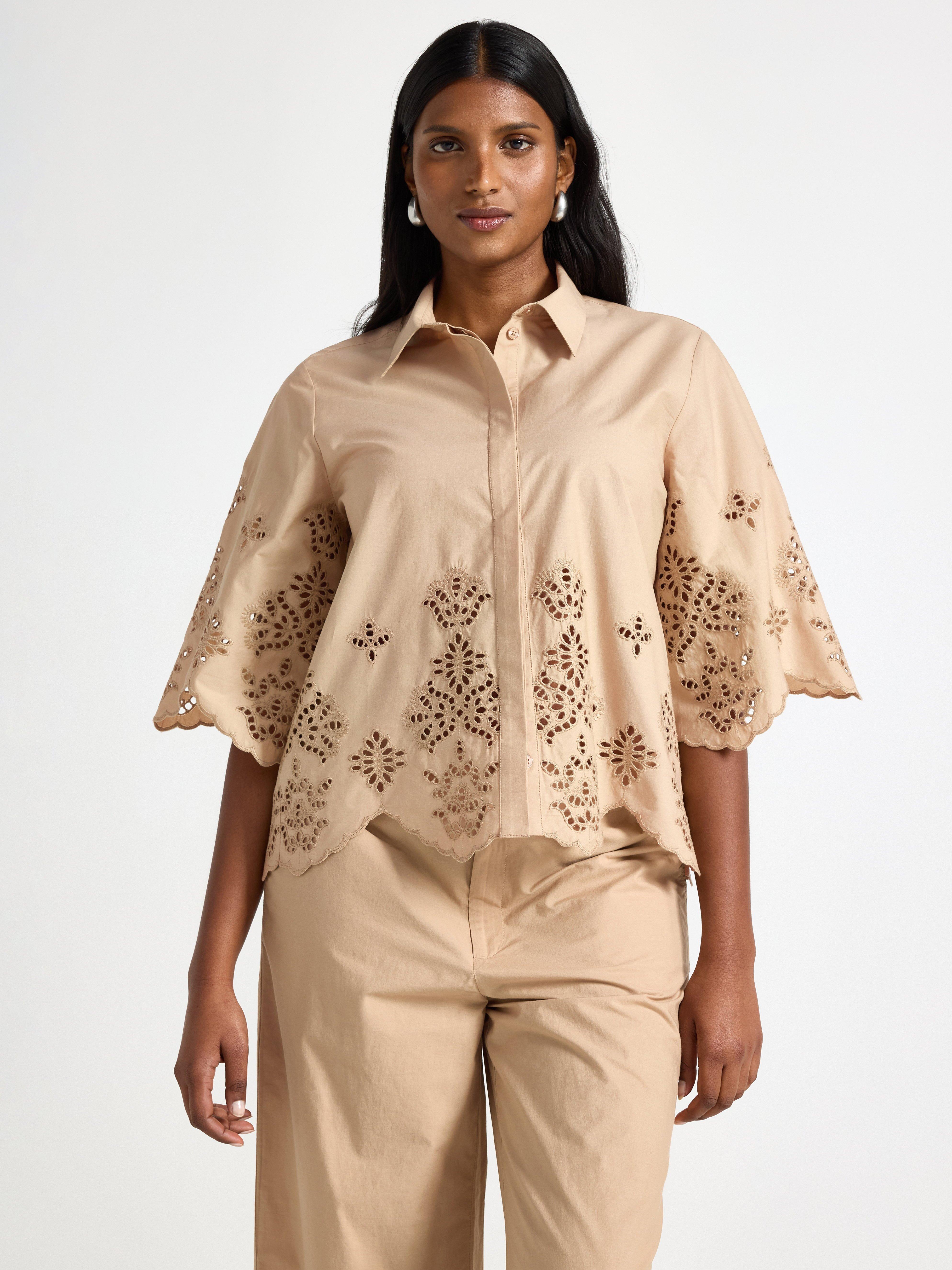 Camisa de manga curta bege com bordado.