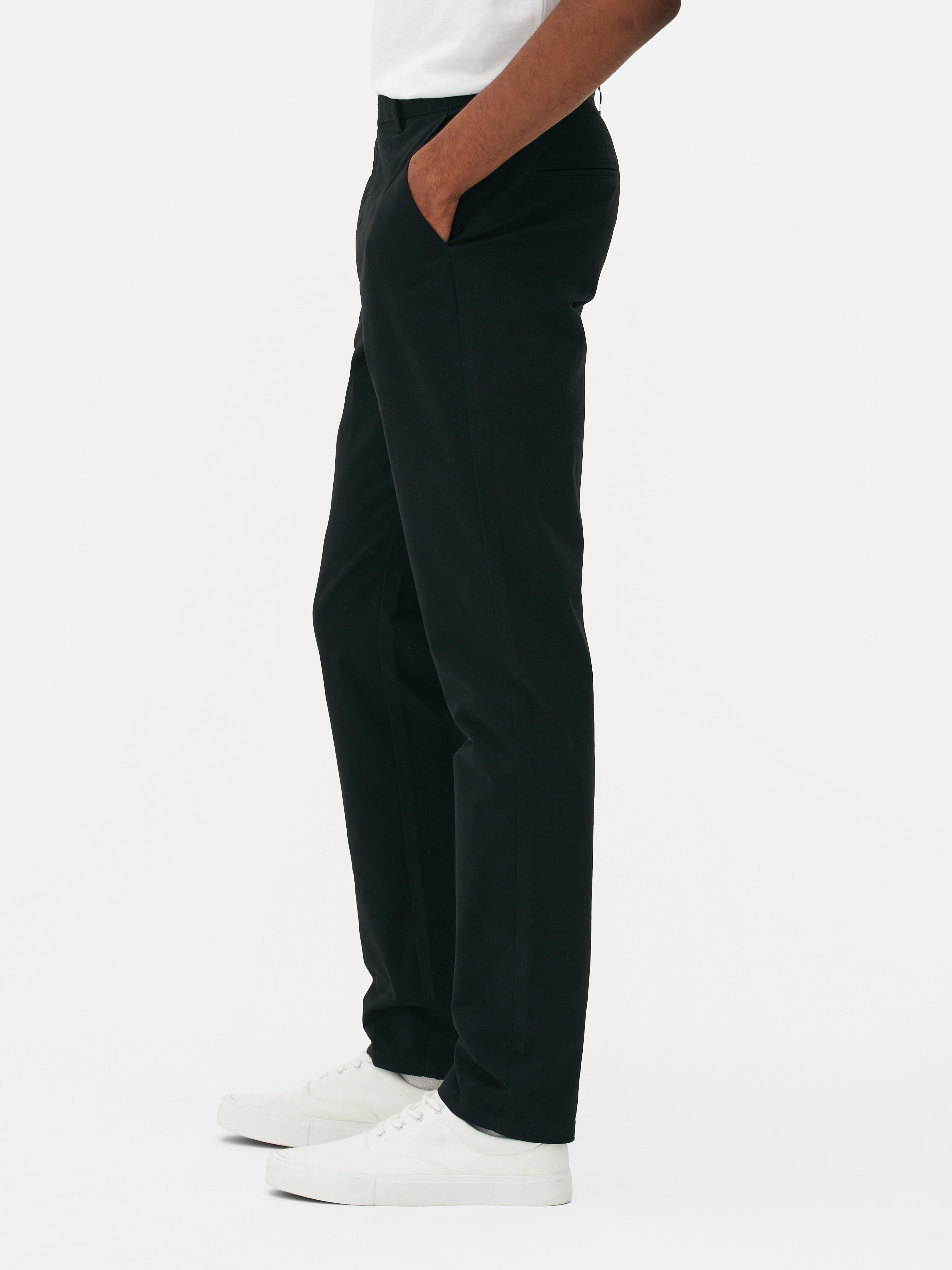 Pantaloni chino elastici, mulați. Pantaloni chino mulați, confecționați în principal din bumbac și cu buzunare laterale.