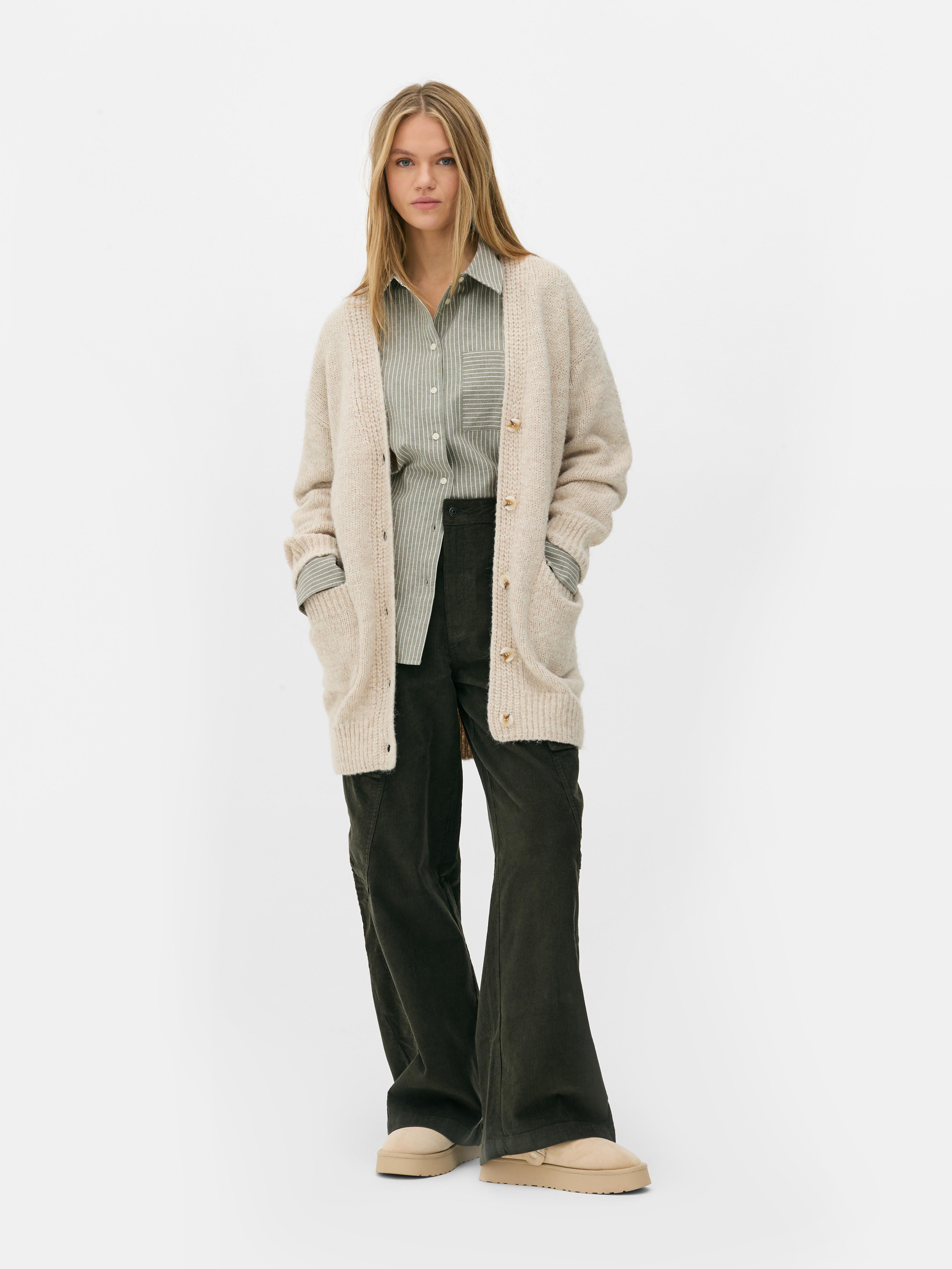 Oversize-Strickjacke. Eine lange Strickjacke mit Oversize-Schnitt, V-Ausschnitt und aufgesetzten Taschen.