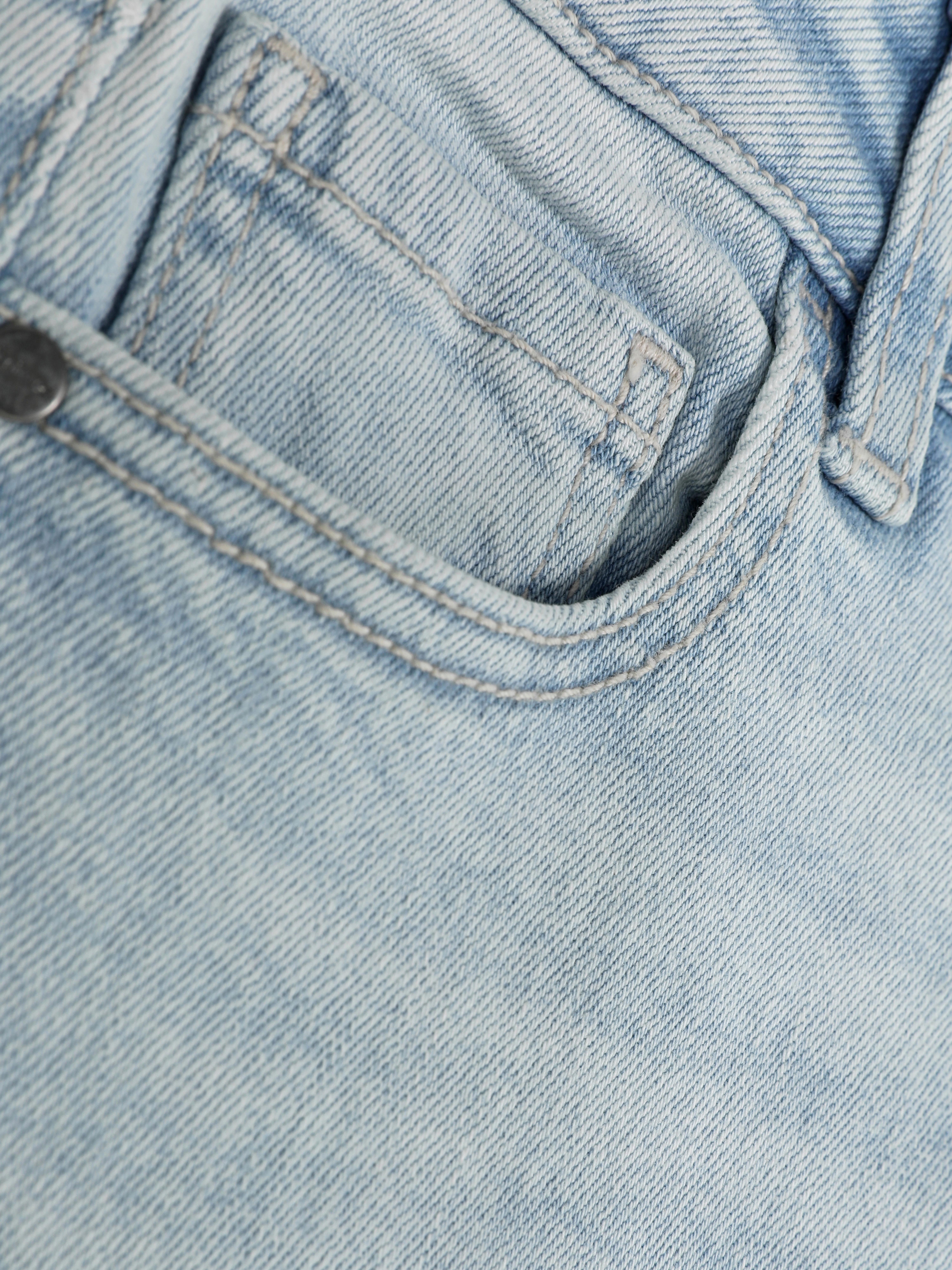 Schmal geschnittene Jeans für Jungen. Eine coole, schmal geschnittene Jeans mit Gürtelschlaufen und Knöpfen vorne.