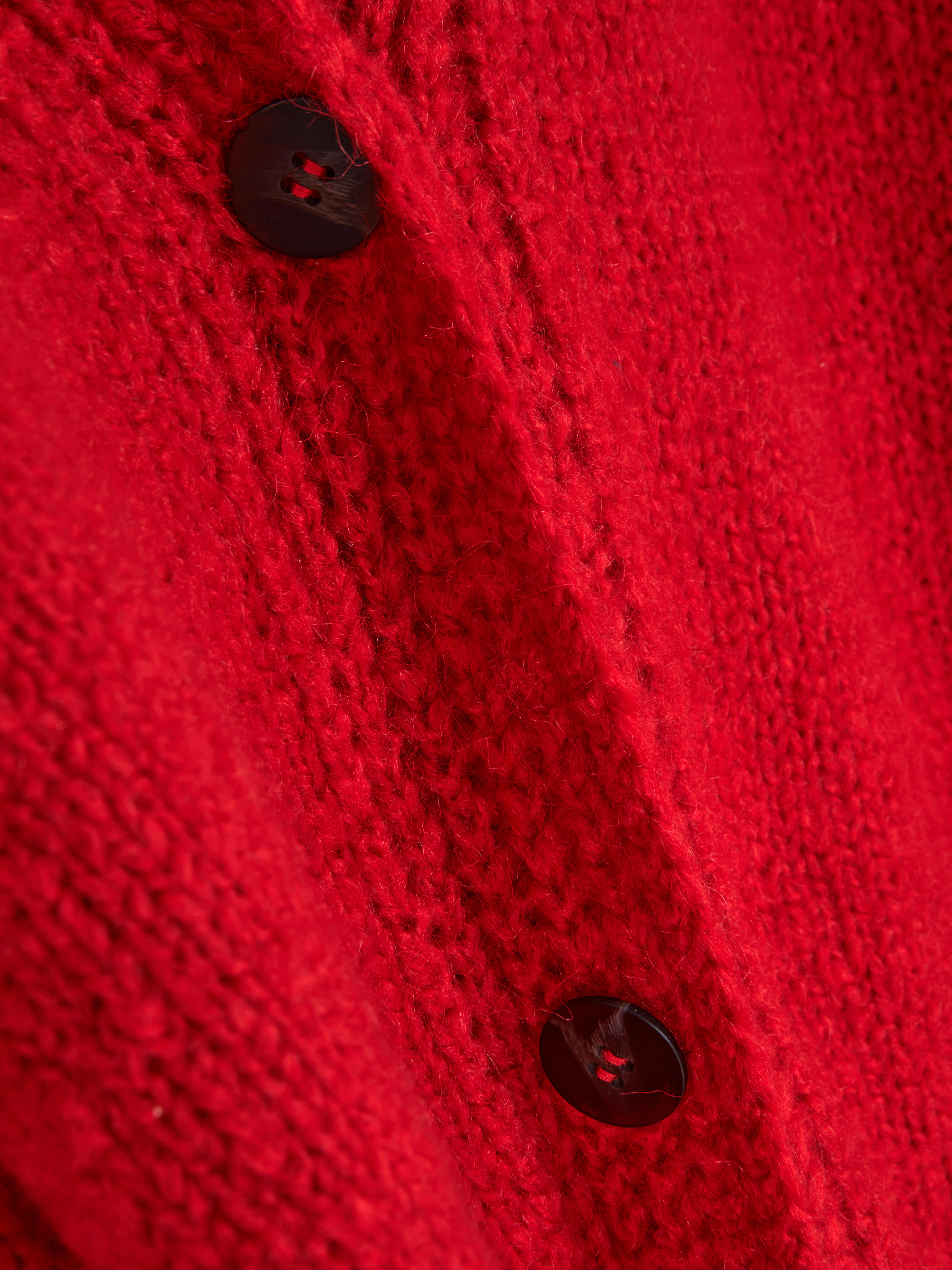 Oversize-Strickjacke. Eine lange Strickjacke mit Oversize-Schnitt, V-Ausschnitt und aufgesetzten Taschen.