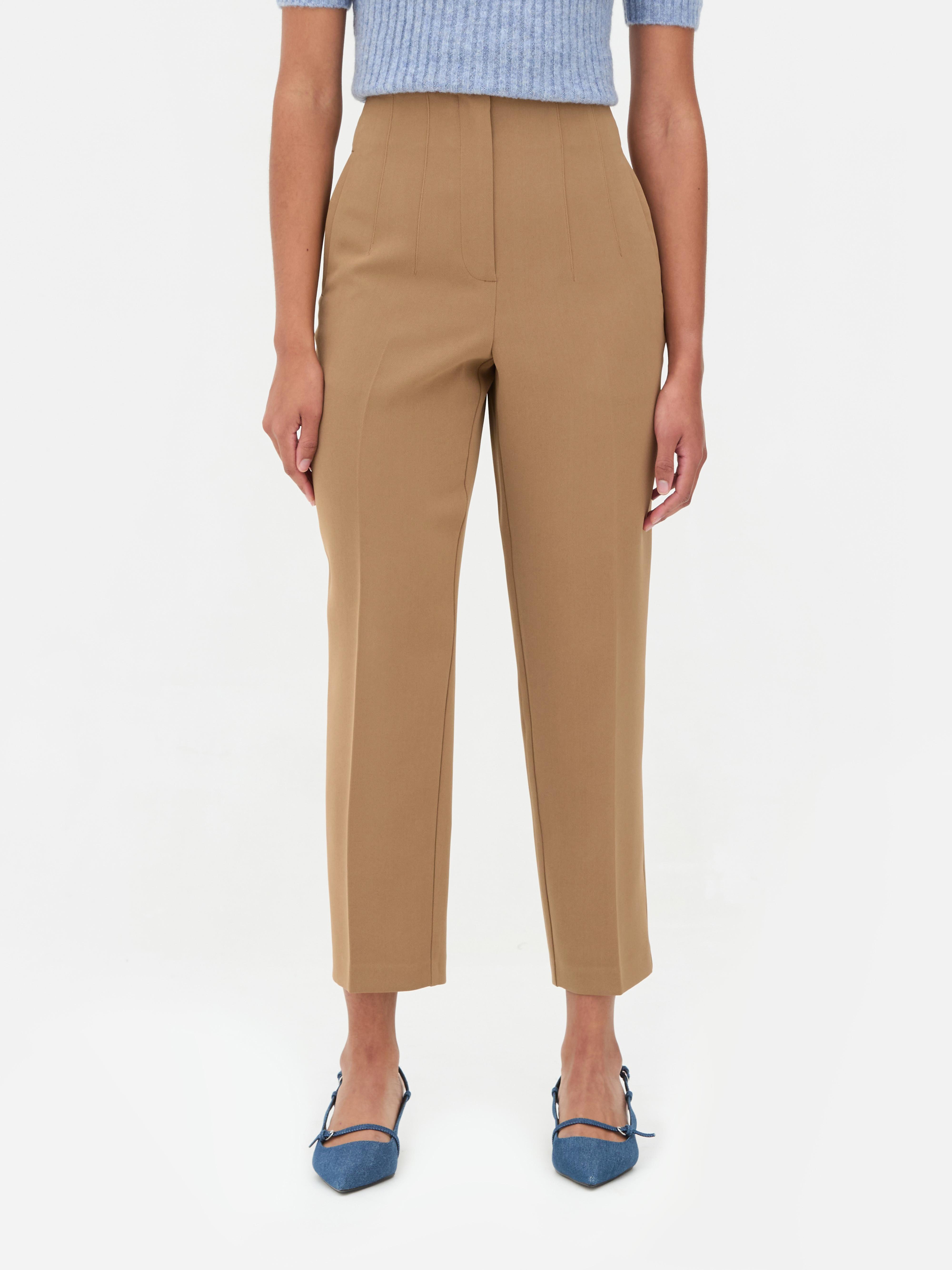 Hochgeschnittene Hose mit Bundfalten. Diese klassische, hochgeschnittene Hose zeichnet sich durch Bundfalten und Bügelfalten aus.