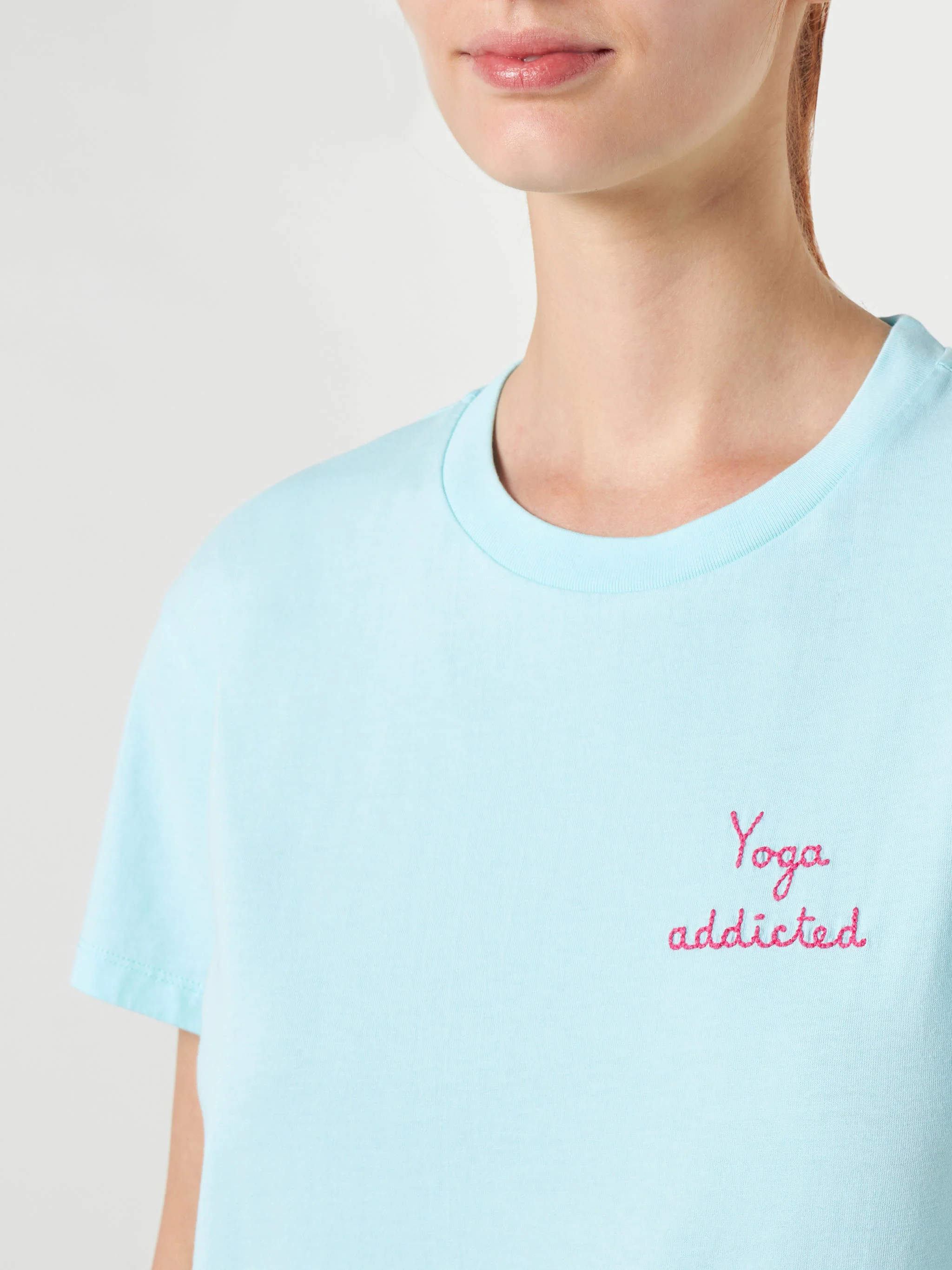 Dames katoenen T-shirt met geborduurde tekst 'yoga addict'.