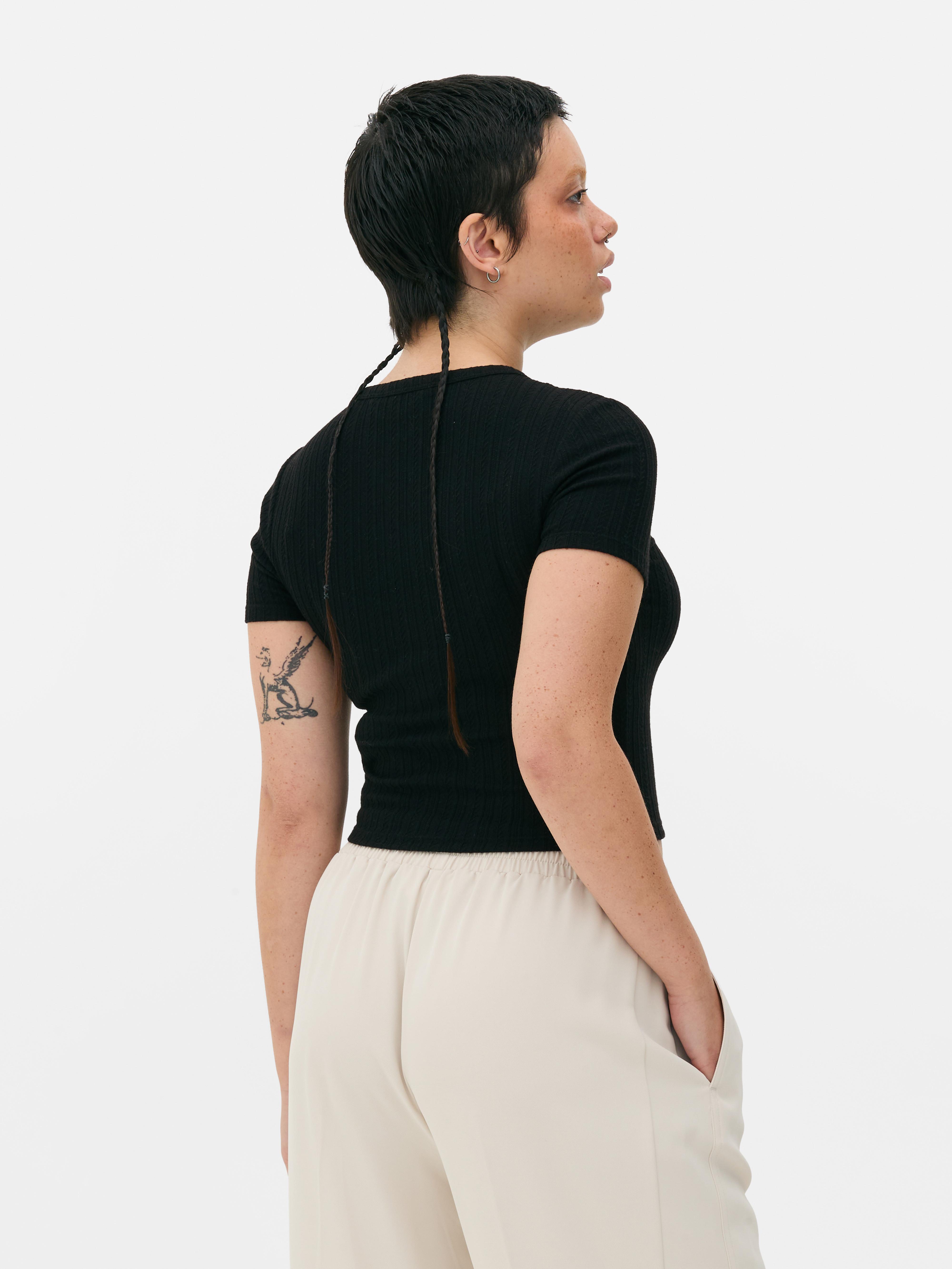 Tricou pentru bebeluși cu imprimeu și model ajurat Un tricou pentru bebeluși cu mâneci scurte, model ajurat și imprimeu pe față