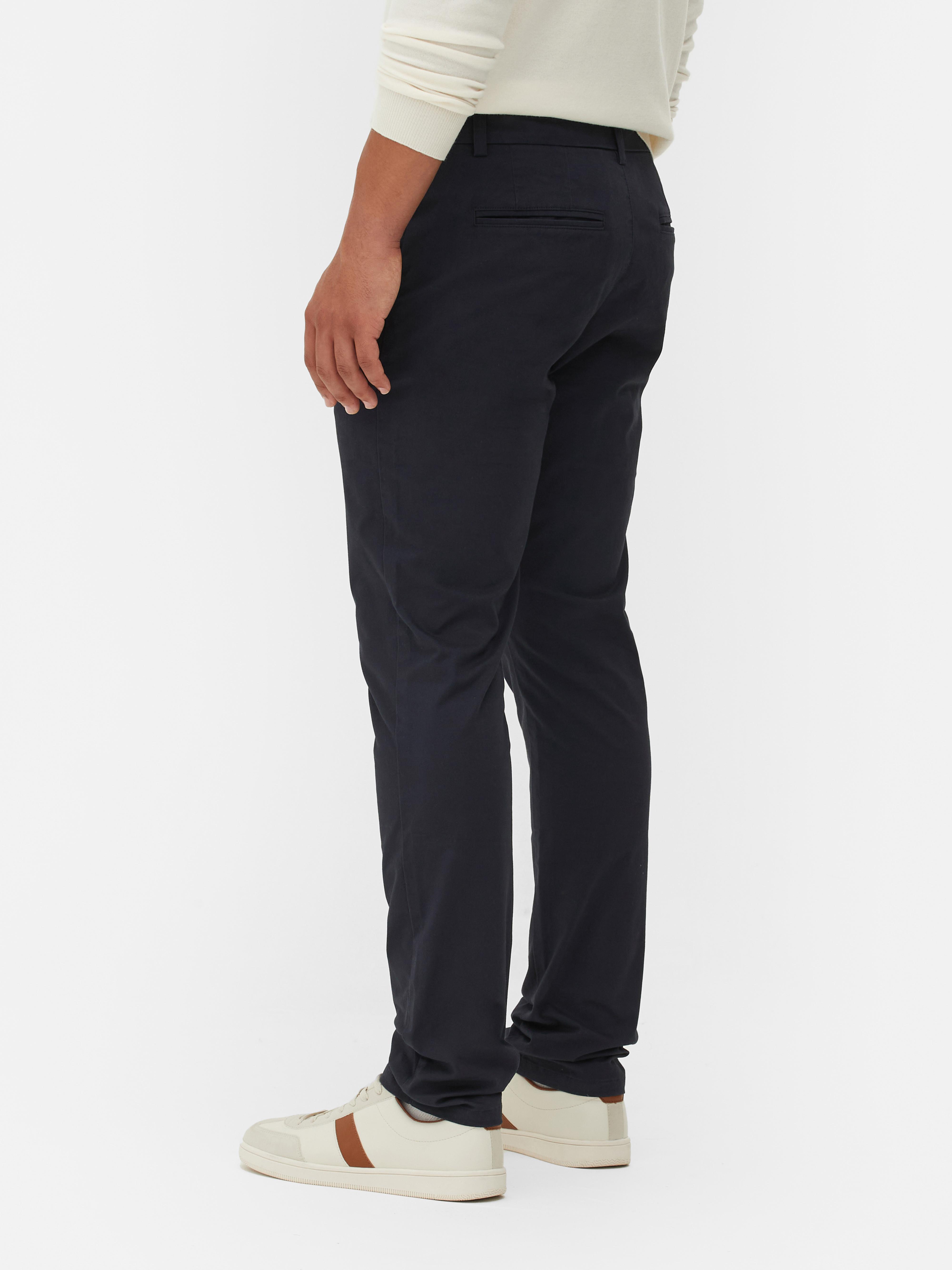 Pantaloni chino elastici, mulați. Pantaloni chino mulați, confecționați în principal din bumbac și cu buzunare laterale.